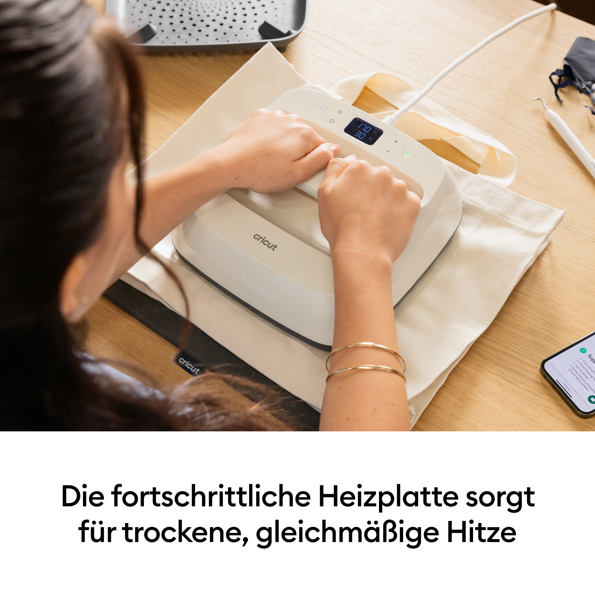 Eine Person benutzt eine Cricut Heißpresse auf einem Stoffbeutel.