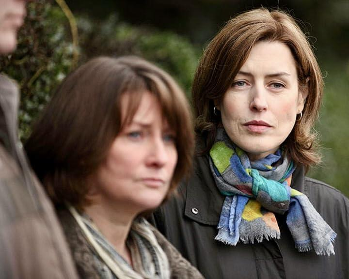 Zwei Frauen stehen draußen, eine trägt einen bunten Schal.