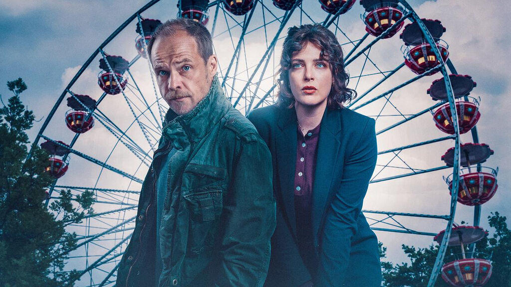Ein Mann und eine Frau stehen vor einem Riesenrad im Freien.