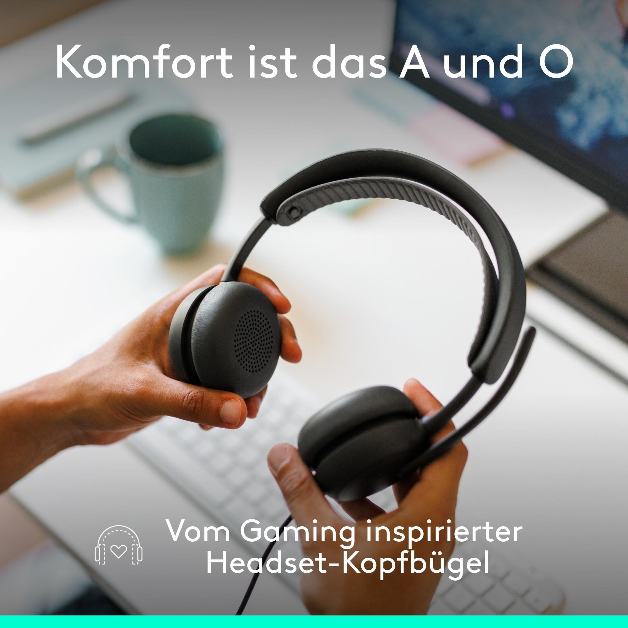 Schwarzer Kopfhörer in Händen vor Schreibtisch und Tasse.