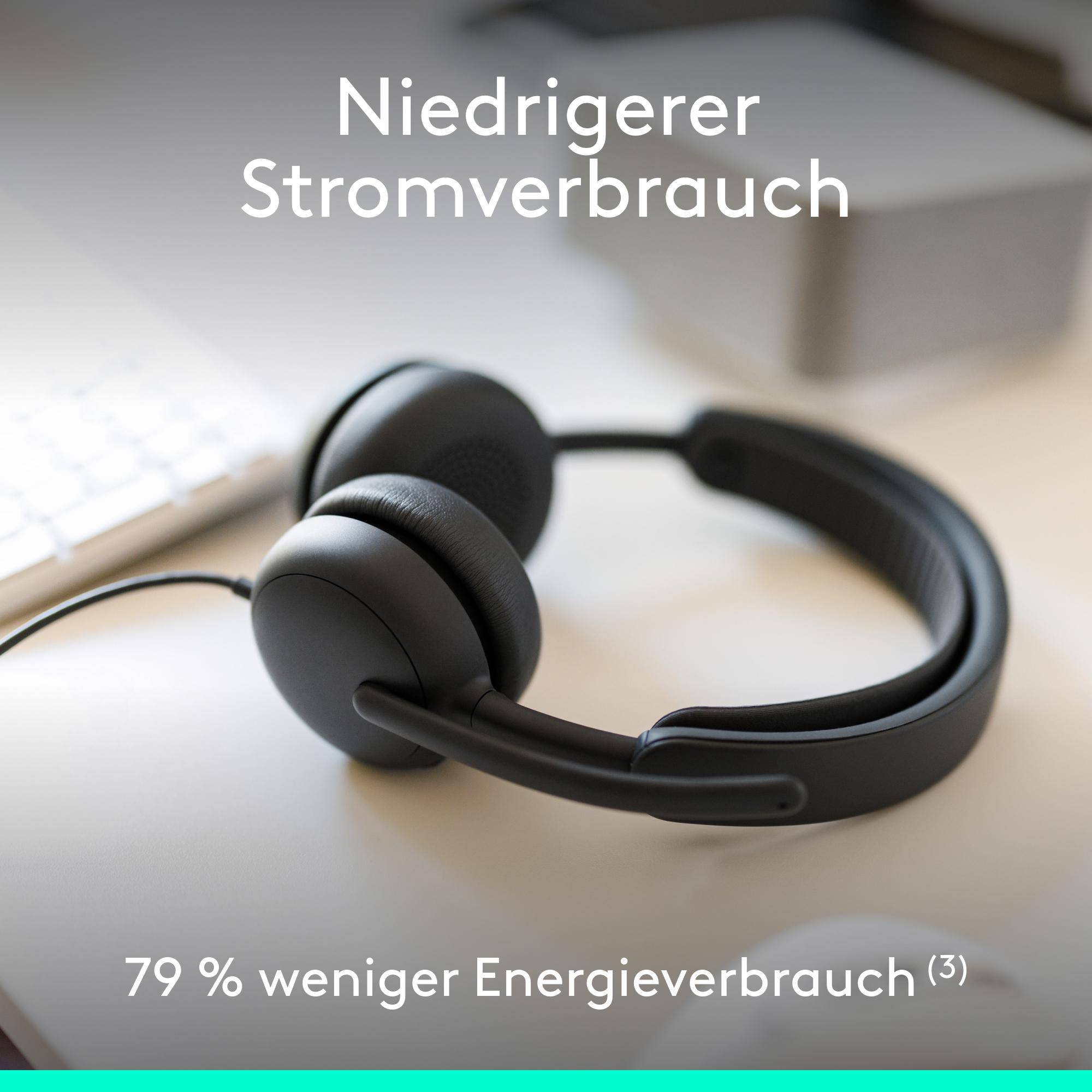 Schwarze Kopfhörer liegen auf einem Schreibtisch neben einer Tastatur.