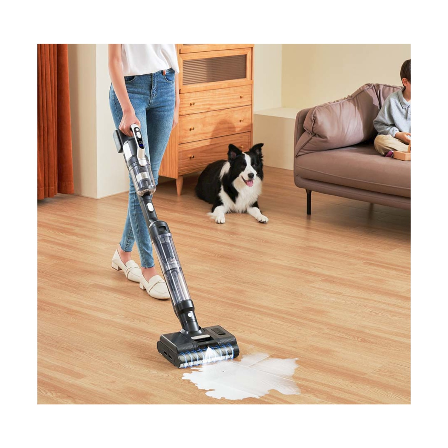 Una donna aspira un liquido versato mentre un cane guarda.