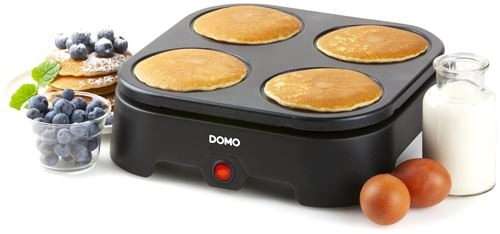 Pancakes on a machine, with blueberries, eggs, and milk beside it.