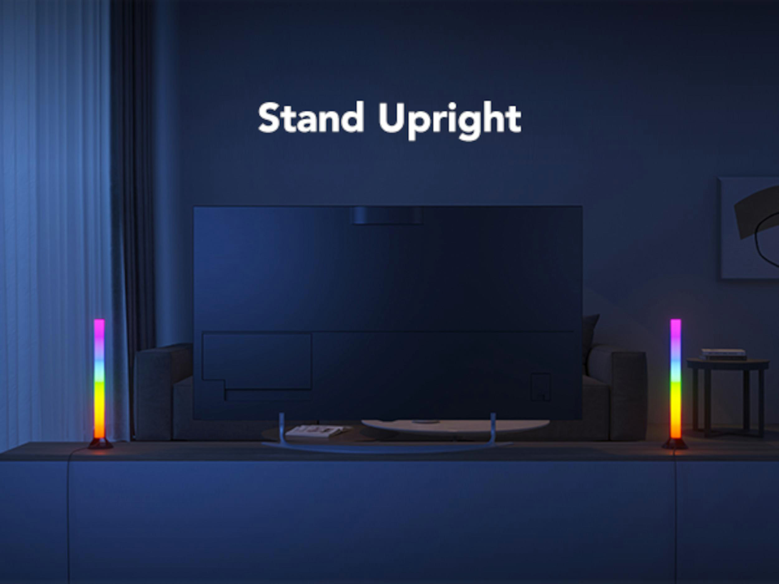 Ein Fernseher steht auf einem Schrank, flankiert von bunten RGB-Lichtern.