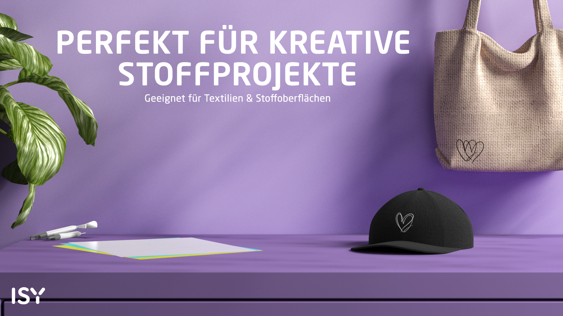 Ein schwarzer Cap mit Herz-Druck, Stofftasche, Papier und Stiften auf lila Fläche.