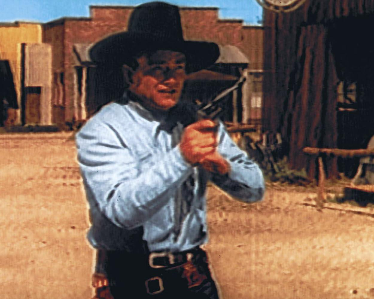 Ein Mann im Western-Outfit mit Hut und Hemd hält eine Pistole in der Hand.