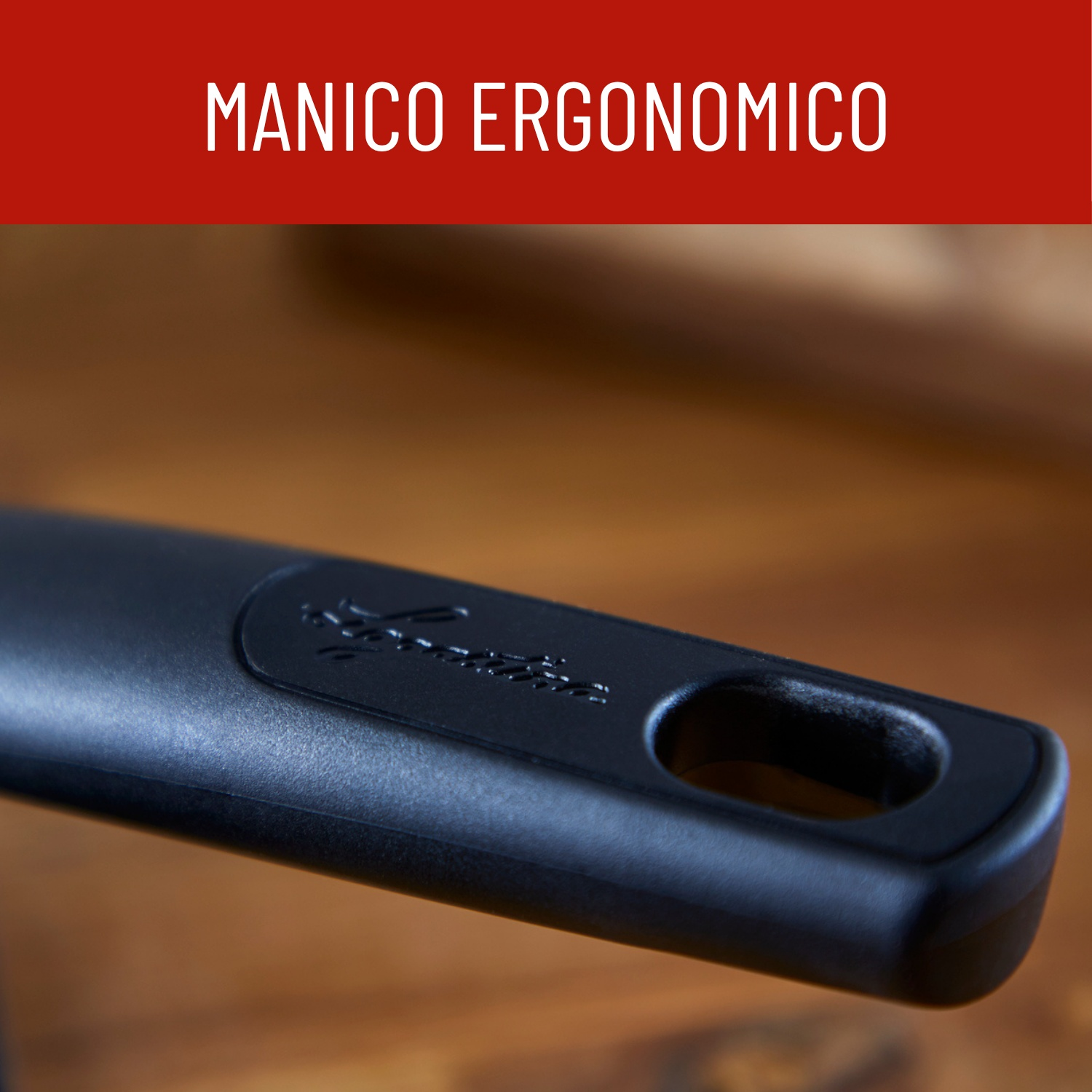 Manico ergonomico nero con foro per appendere su superficie in legno.
