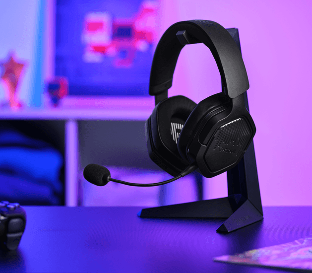 Fekete gamer fejhallgató mikrofonnal állványon, lila és kék világítás.