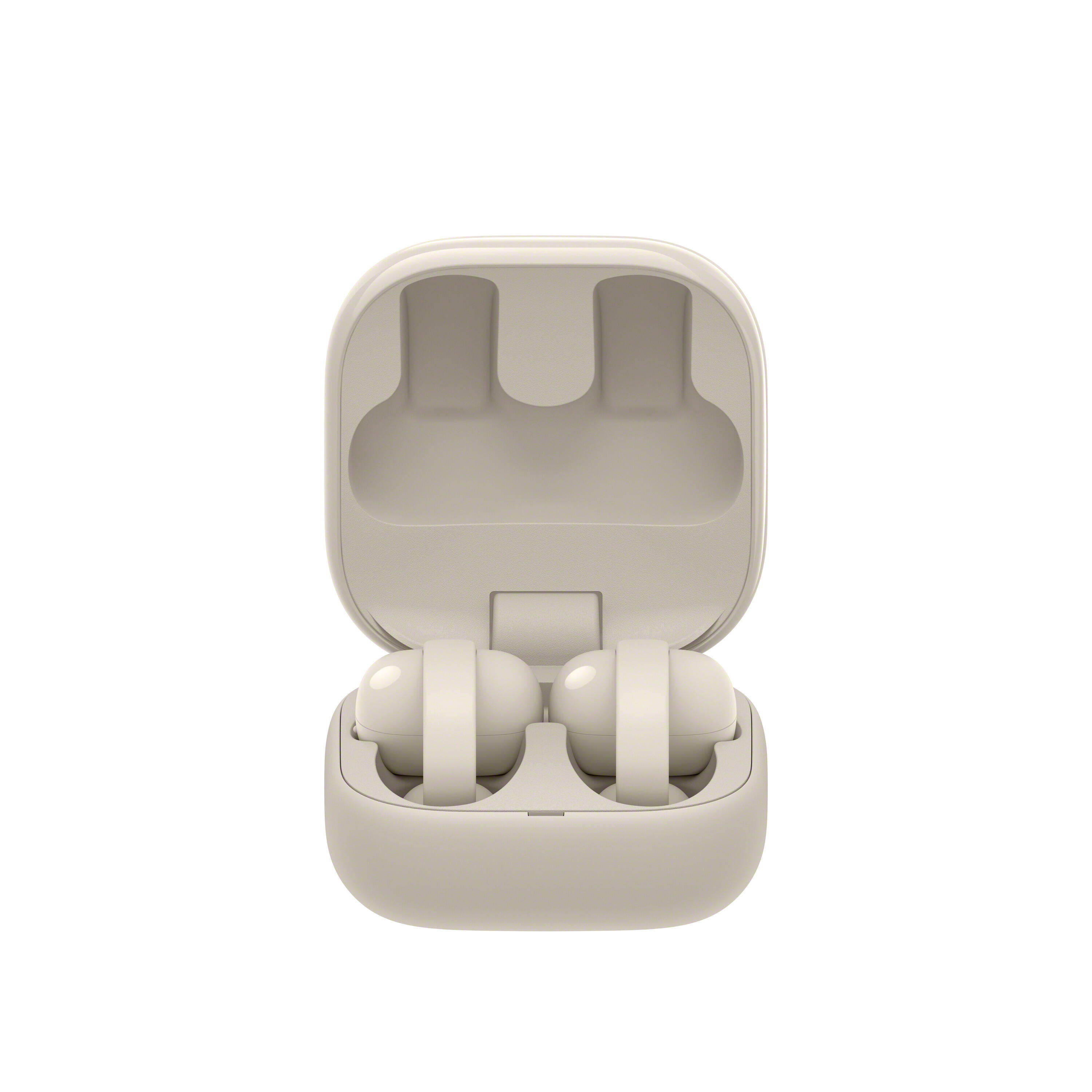 Un juego de auriculares inalámbricos beige claro en su estuche de carga abierto.
