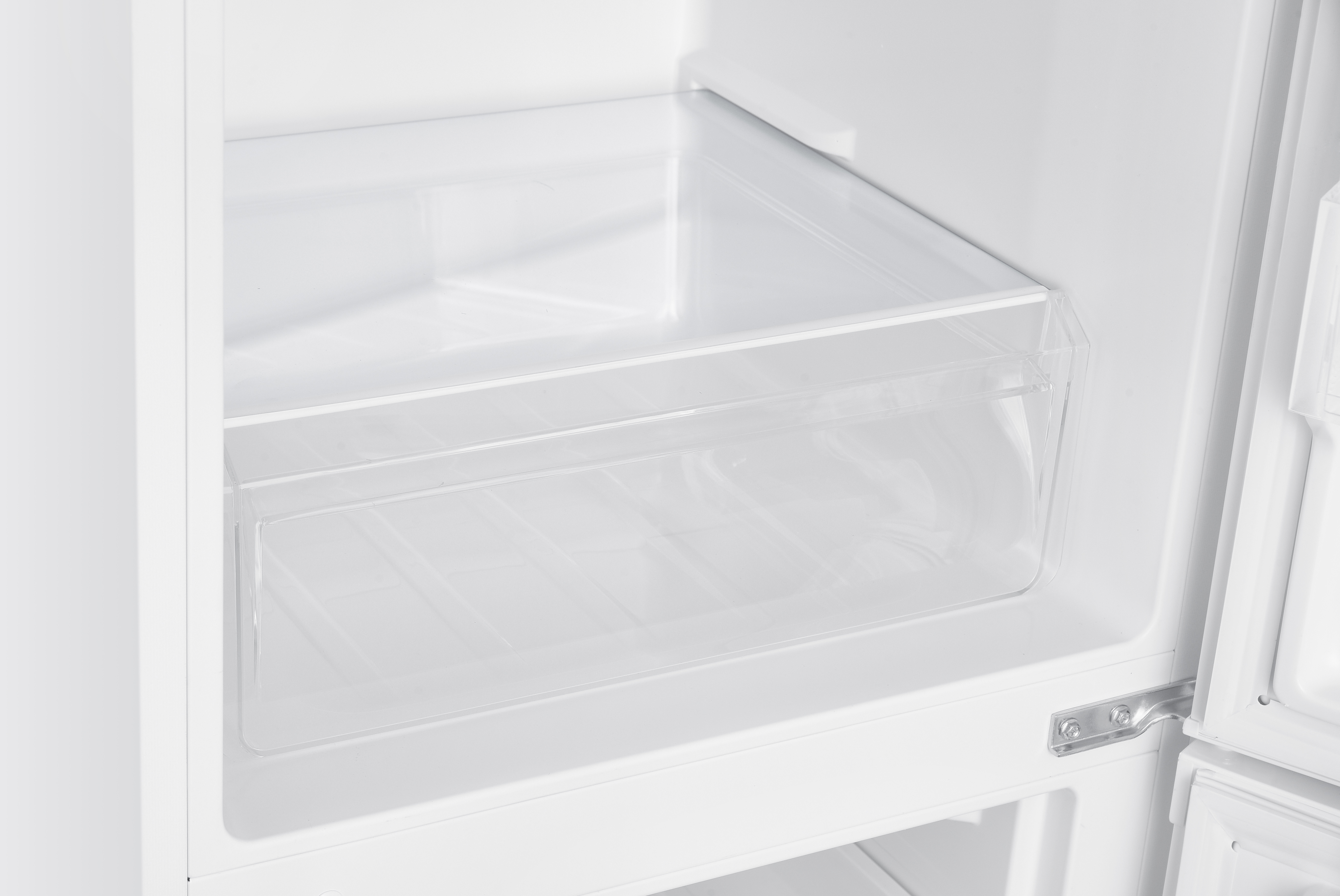 Un refrigerador blanco vacío con un cajón de plástico transparente.