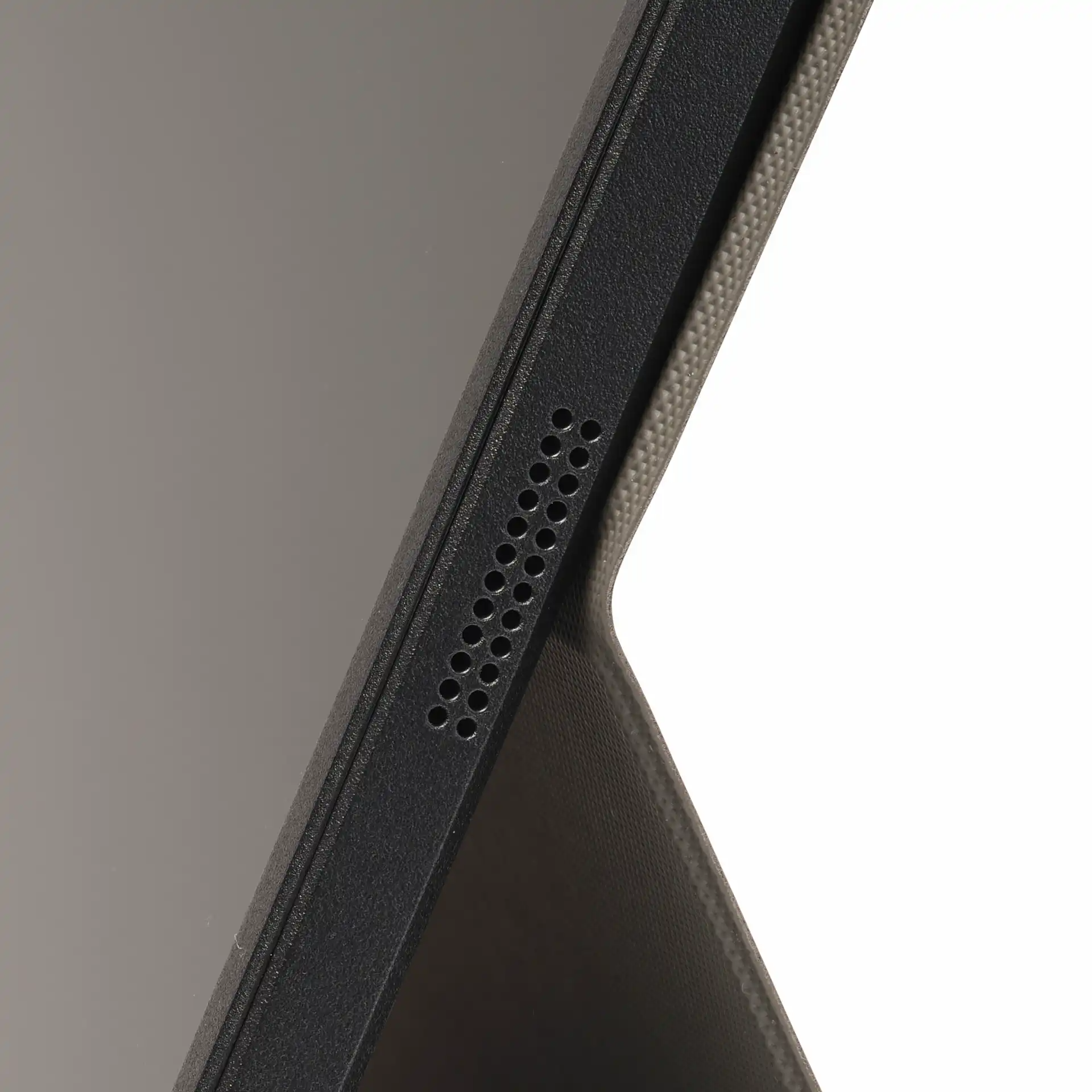 Egy tablet fekete hangszórórácsának közelképe, szövet tokkal.