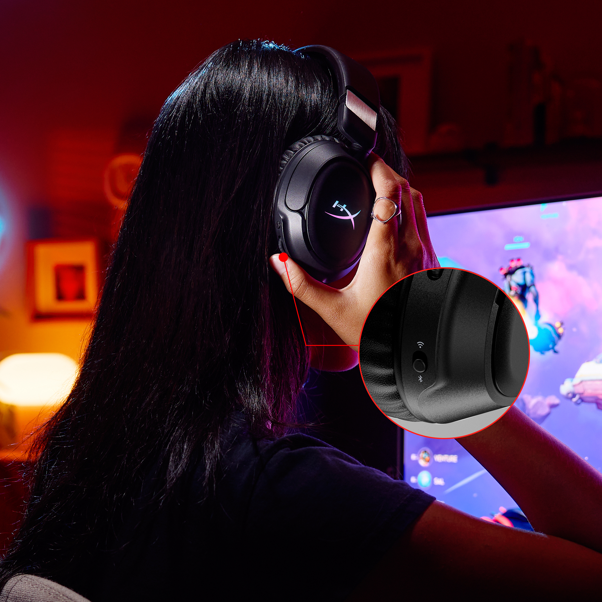 Una persona con auriculares juega un videojuego en un monitor iluminado.
