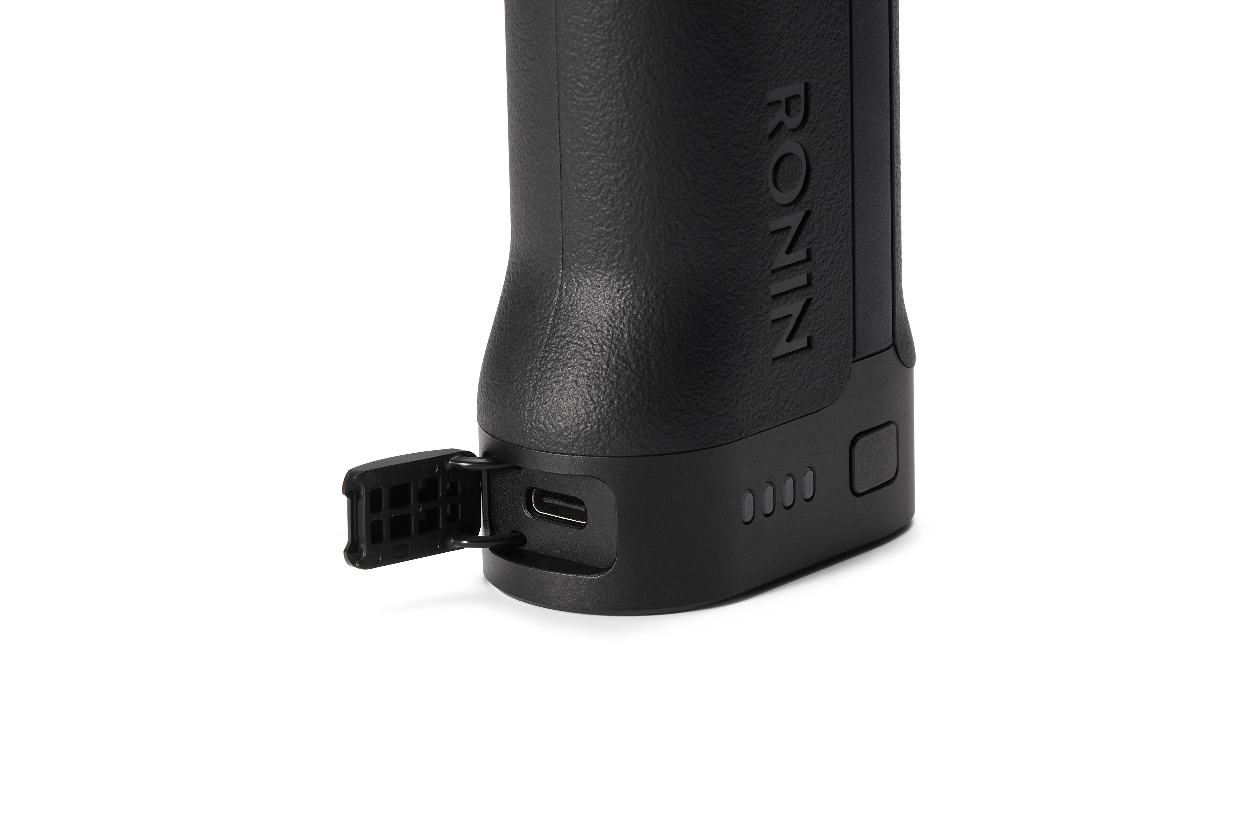 Nahaufnahme eines schwarzen DJI Ronin Kamerastabilisatorgriffs mit geöffneter Anschlussabdeckung, die einen USB-C-Anschluss freigibt.