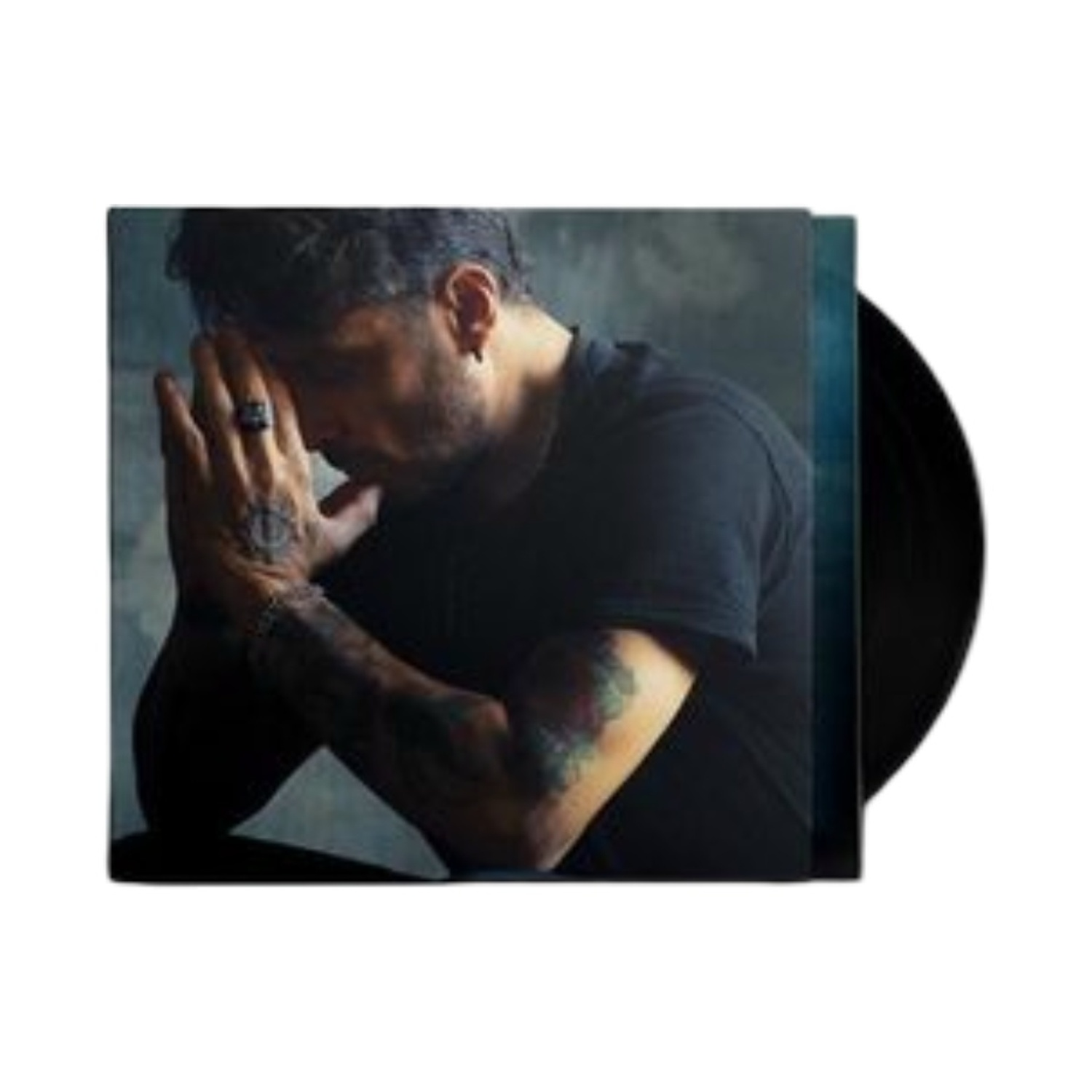 Una copertina di vinile mostra un uomo in camicia nera, capelli scuri, tatuaggi e un anello, mani giunte, rivolto a destra.
