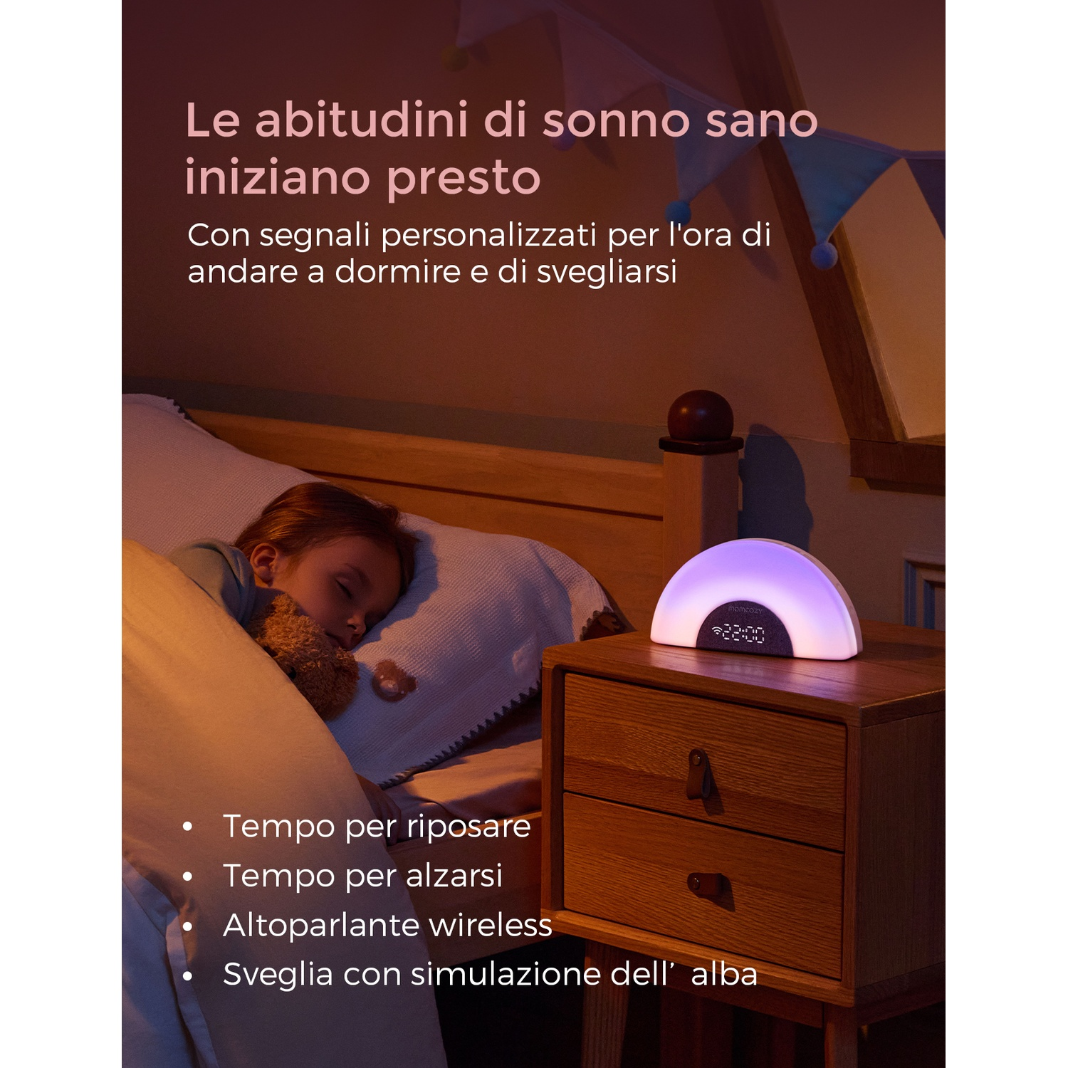 Un bambino dorme a letto accanto a un comodino con una sveglia.