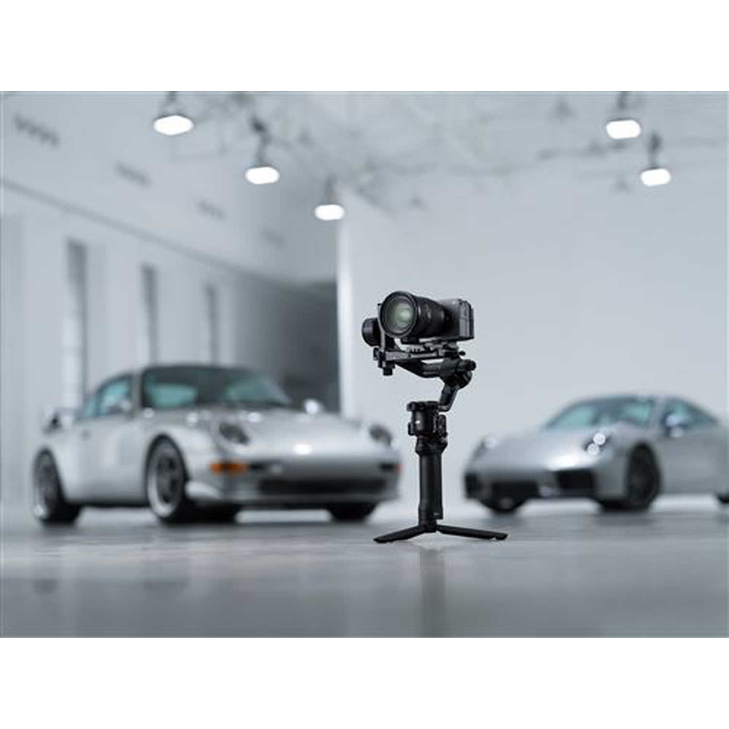 Een gimbal met camera voor twee zilveren sportwagens.