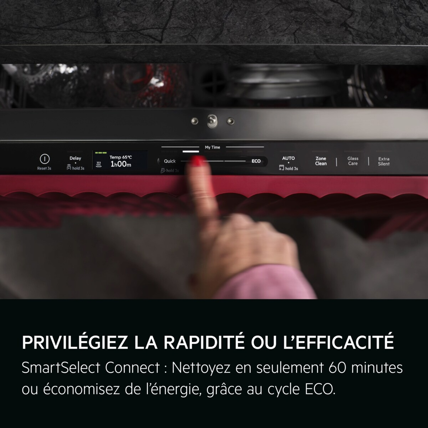 Une main sélectionne un programme sur le panneau de commande d'un lave-vaisselle.