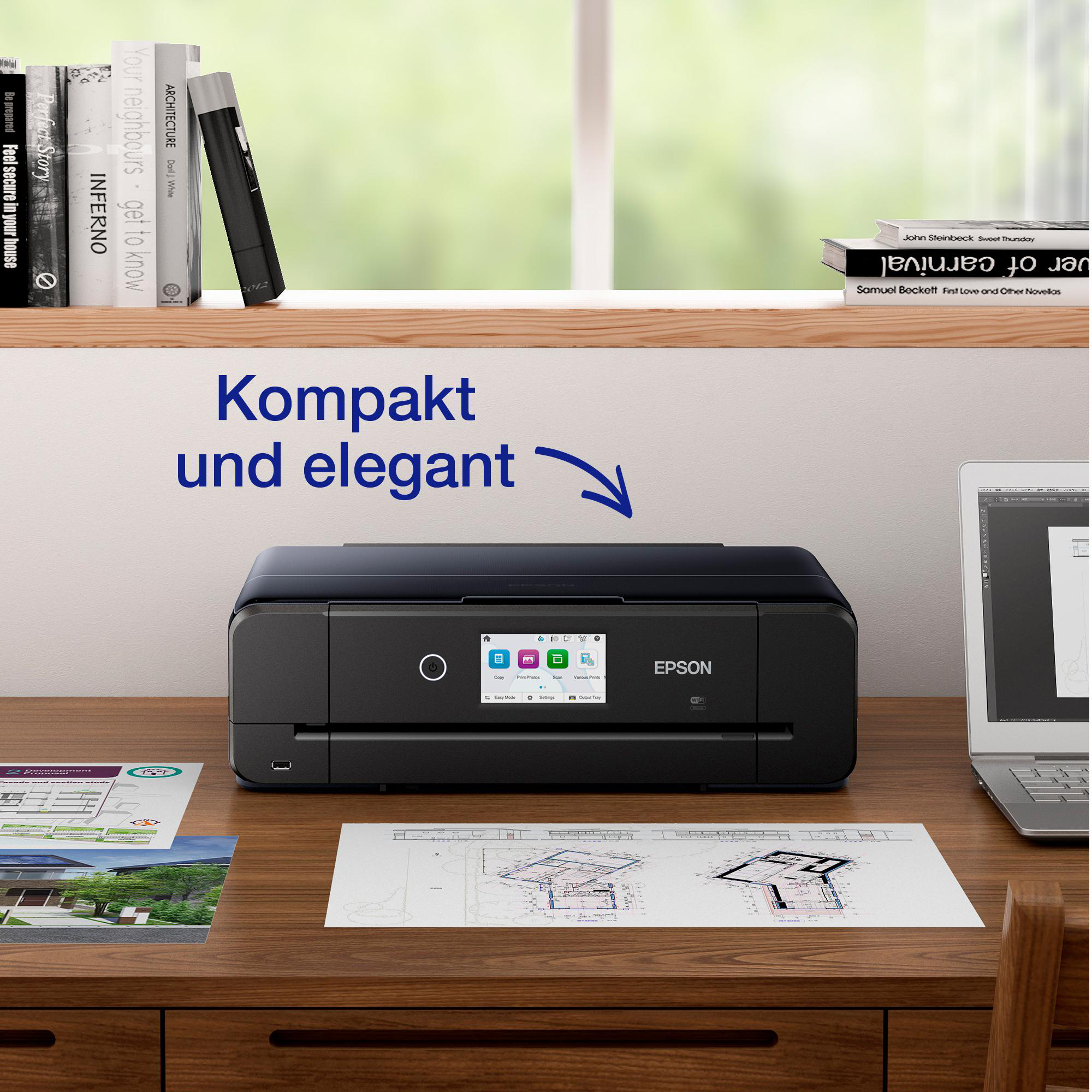 Ein schwarzer Epson-Drucker steht auf einem Schreibtisch neben einem Laptop und Dokumenten.