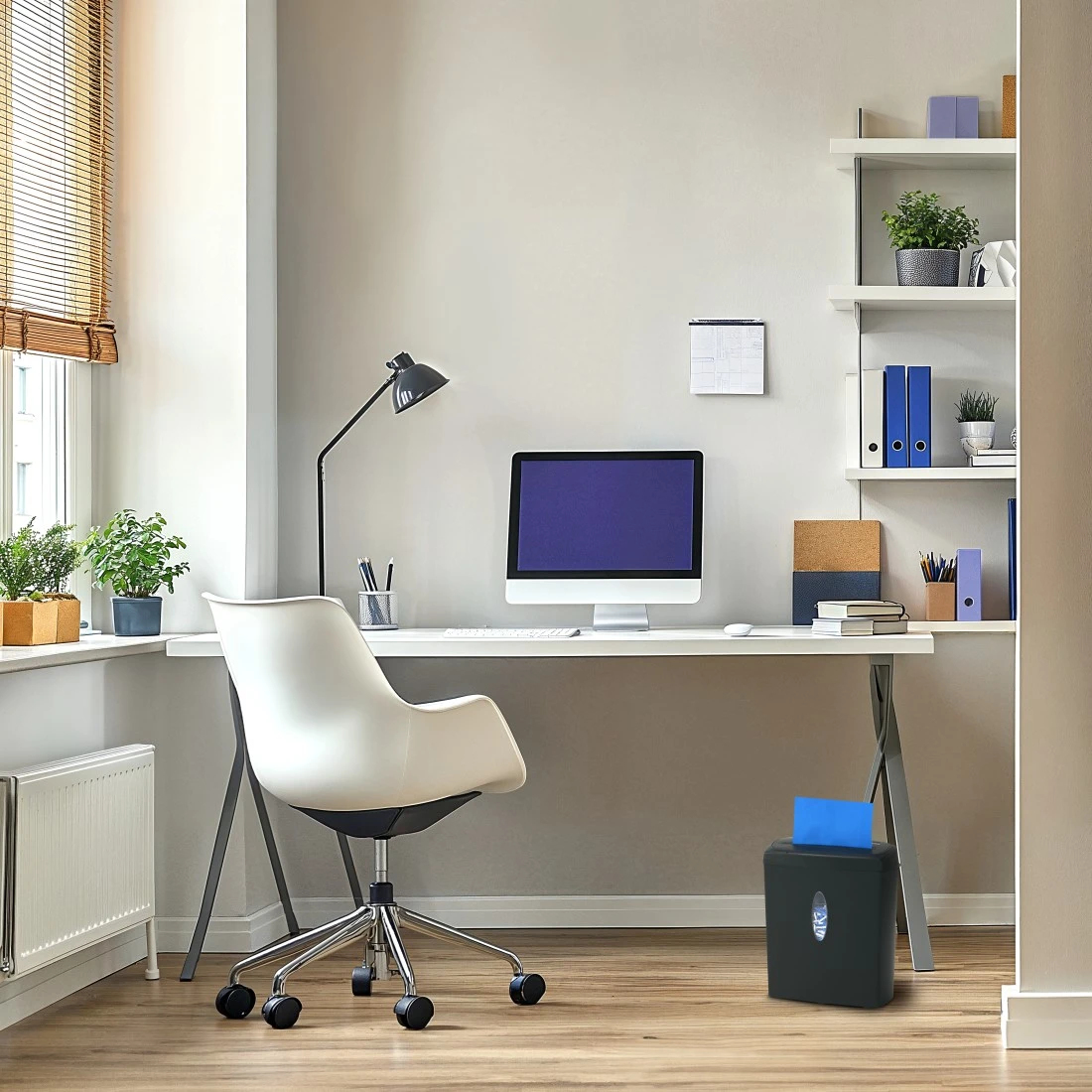 Un escritorio moderno con ordenador, lámpara y silla blanca en una oficina luminosa.