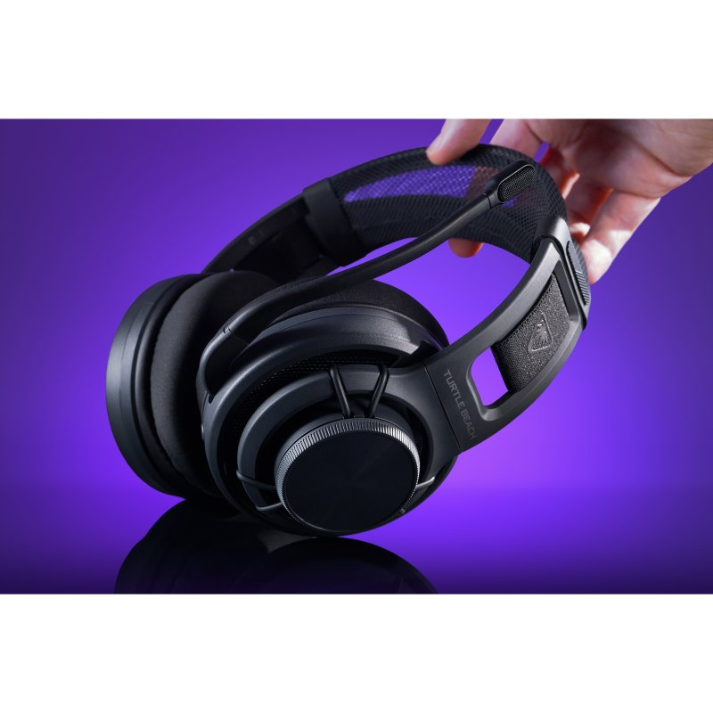 Auriculares negros con diadema, sostenidos por una mano sobre fondo morado.