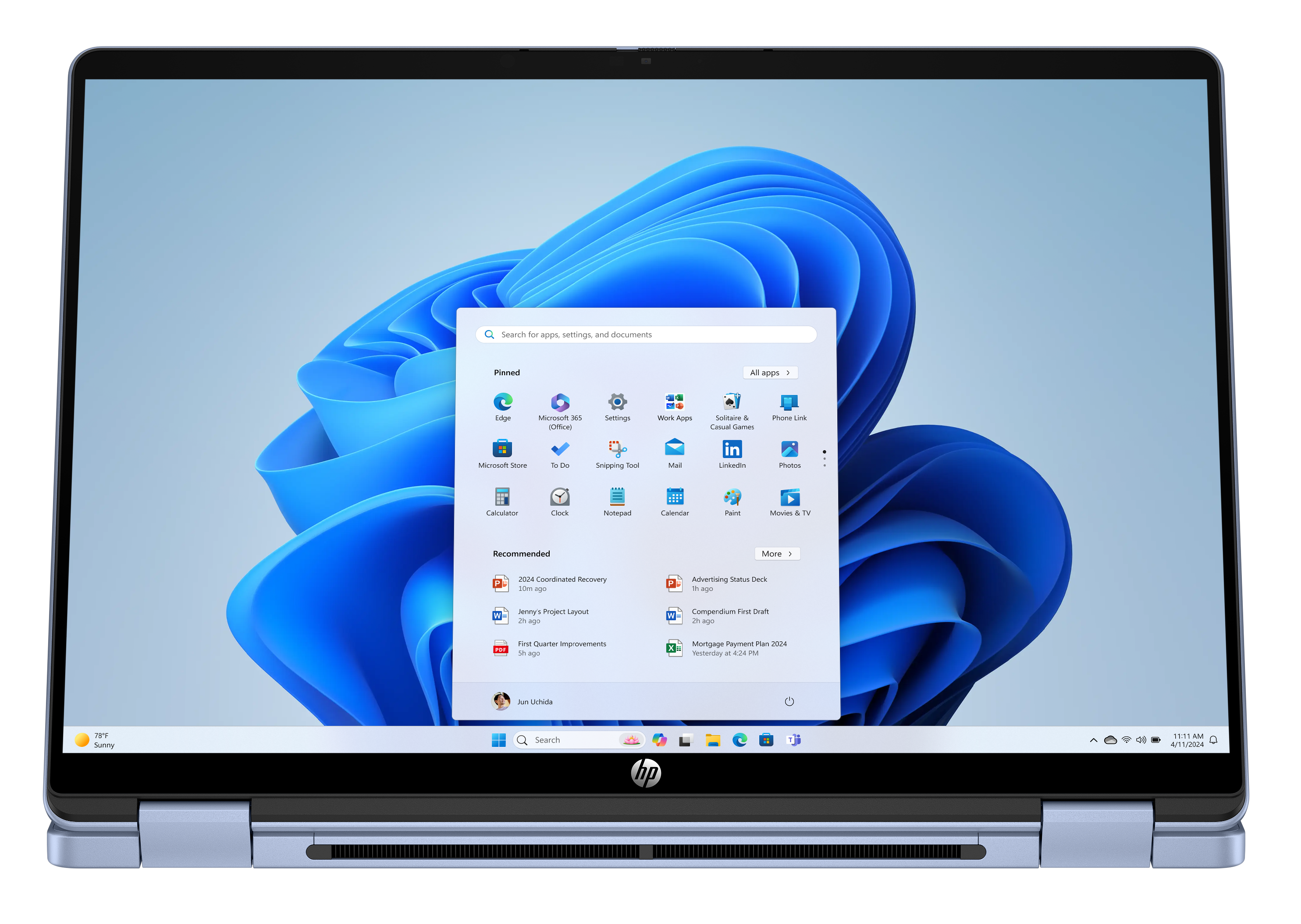 Laptop z systemem Windows 11 pokazuje niebieskie tło z menu start.