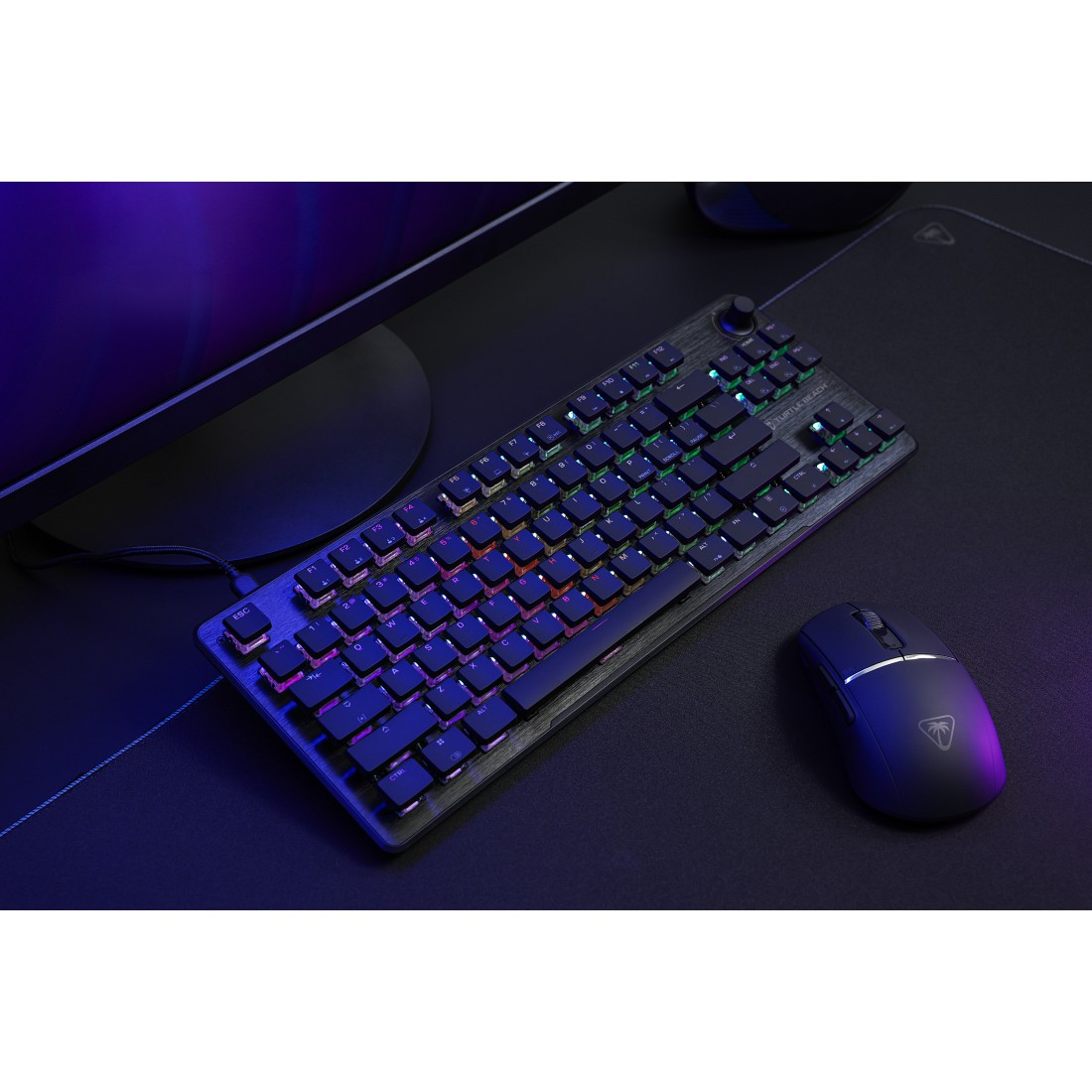 Eine Gaming-Tastatur und -Maus mit RGB-Beleuchtung auf einem schwarzen Schreibtisch.