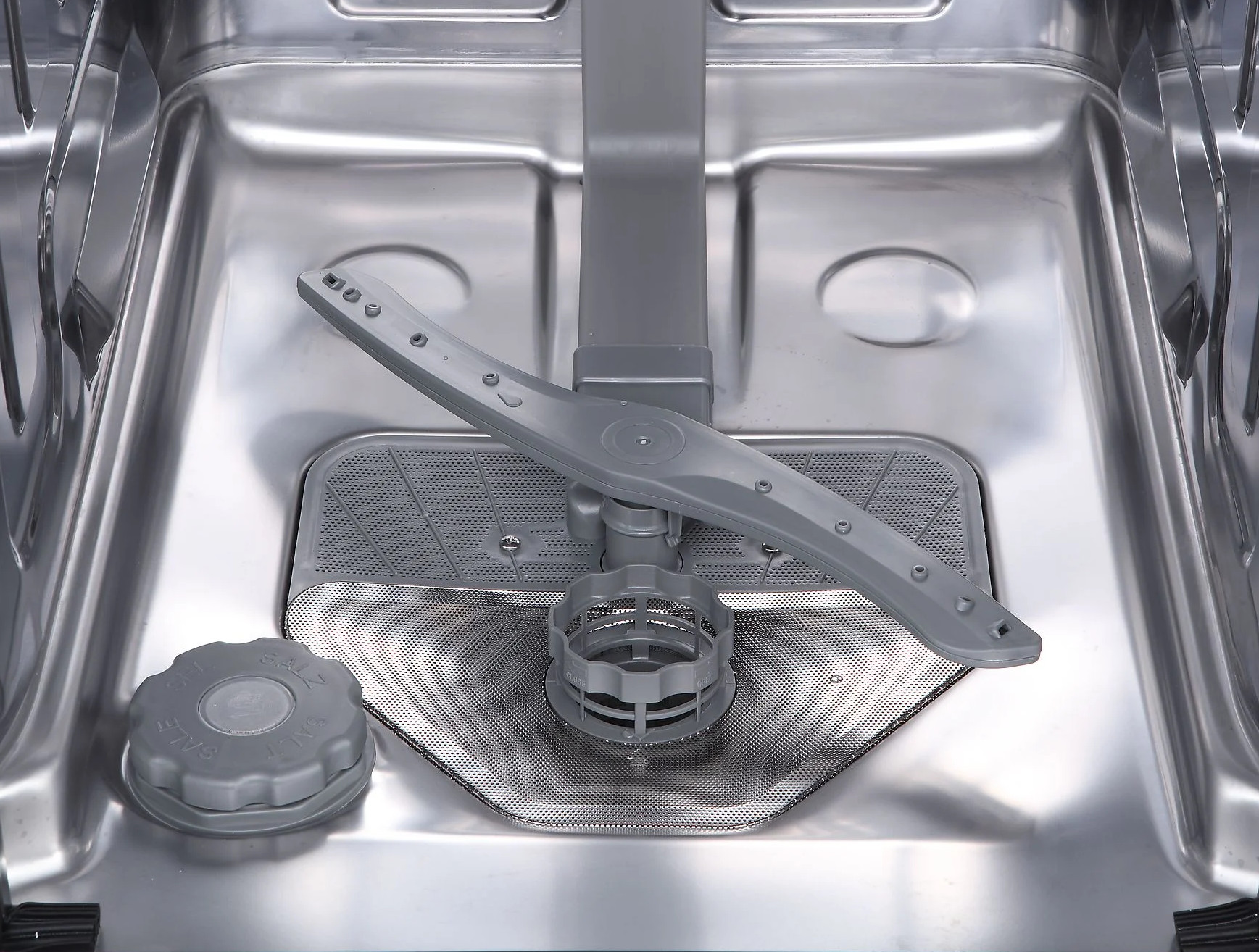 Wnętrze zmywarki z ramieniem spryskującym i dozownikiem soli.