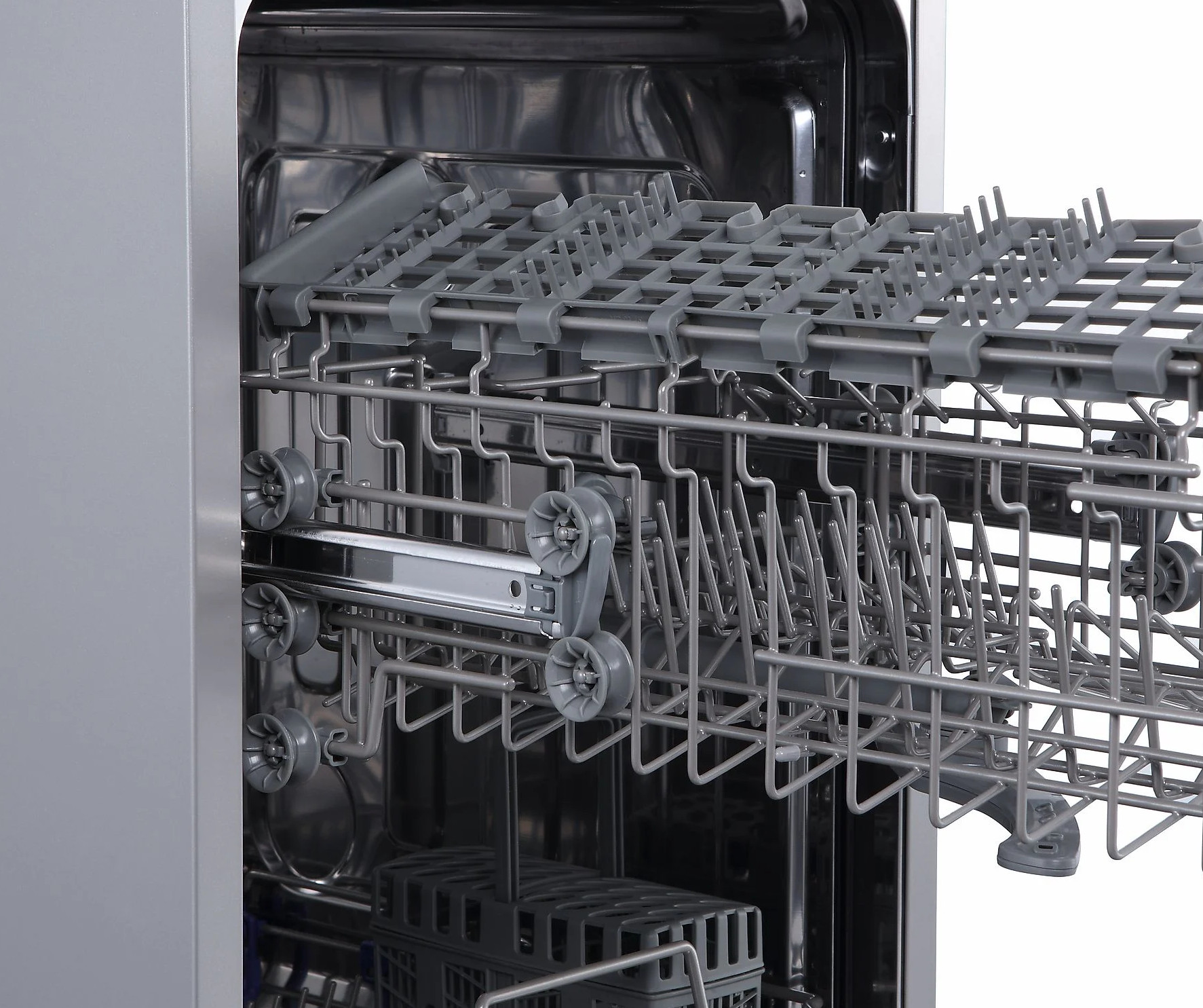 Wnętrze zmywarki z wysuniętymi koszami i uchwytami.