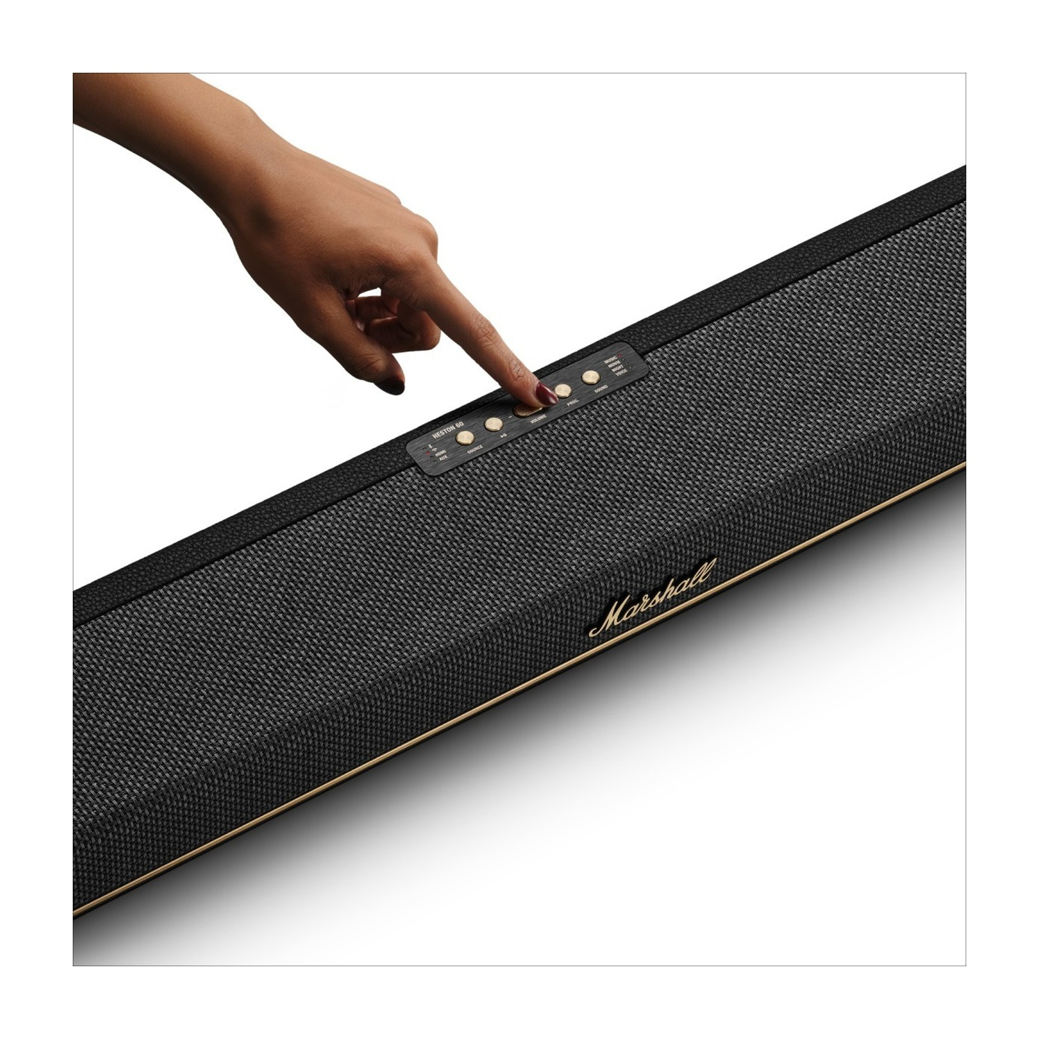 Una mano preme i controlli su uno speaker Marshall nero con finiture dorate.