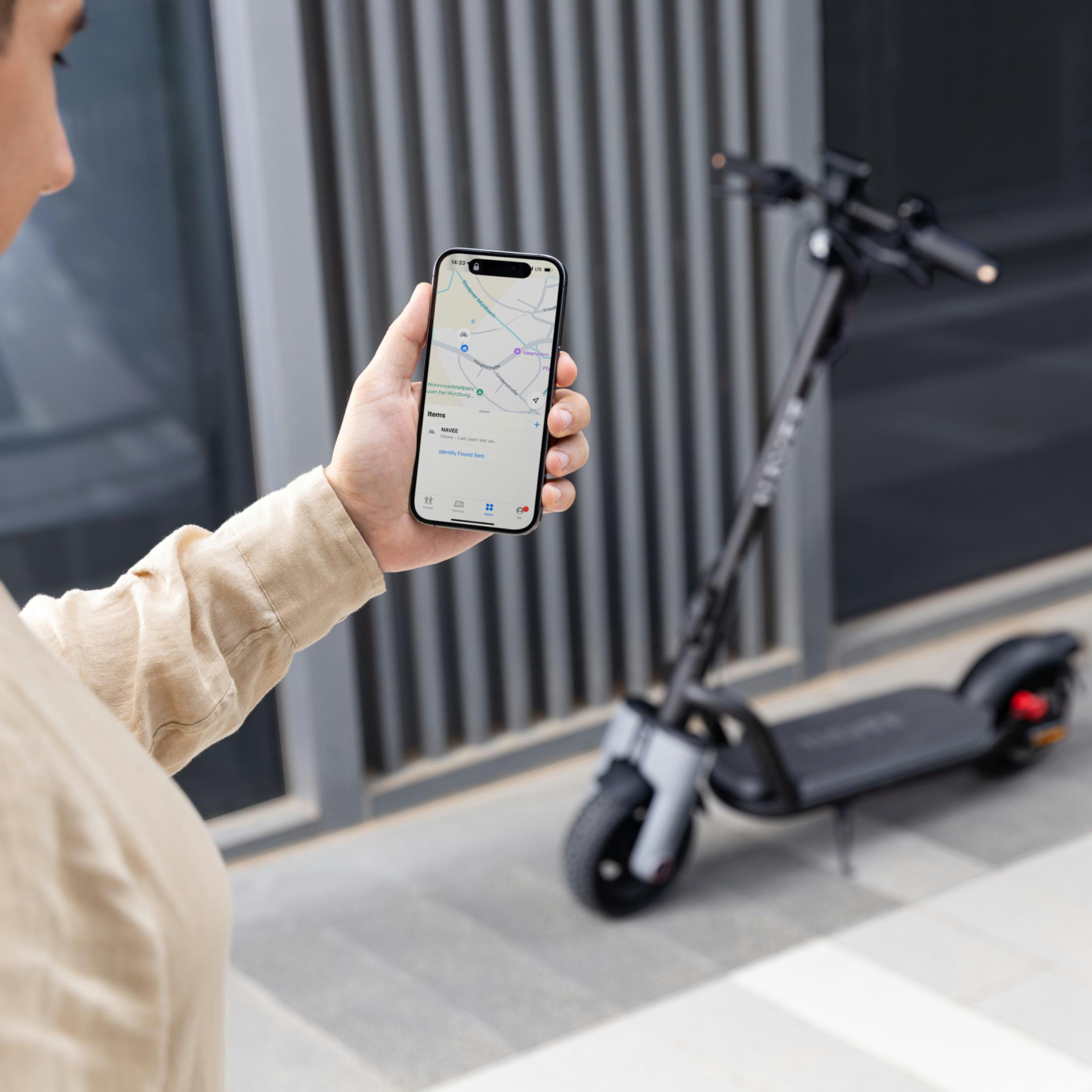 Mann hält Smartphone mit E-Scooter-App, E-Scooter im Hintergrund.