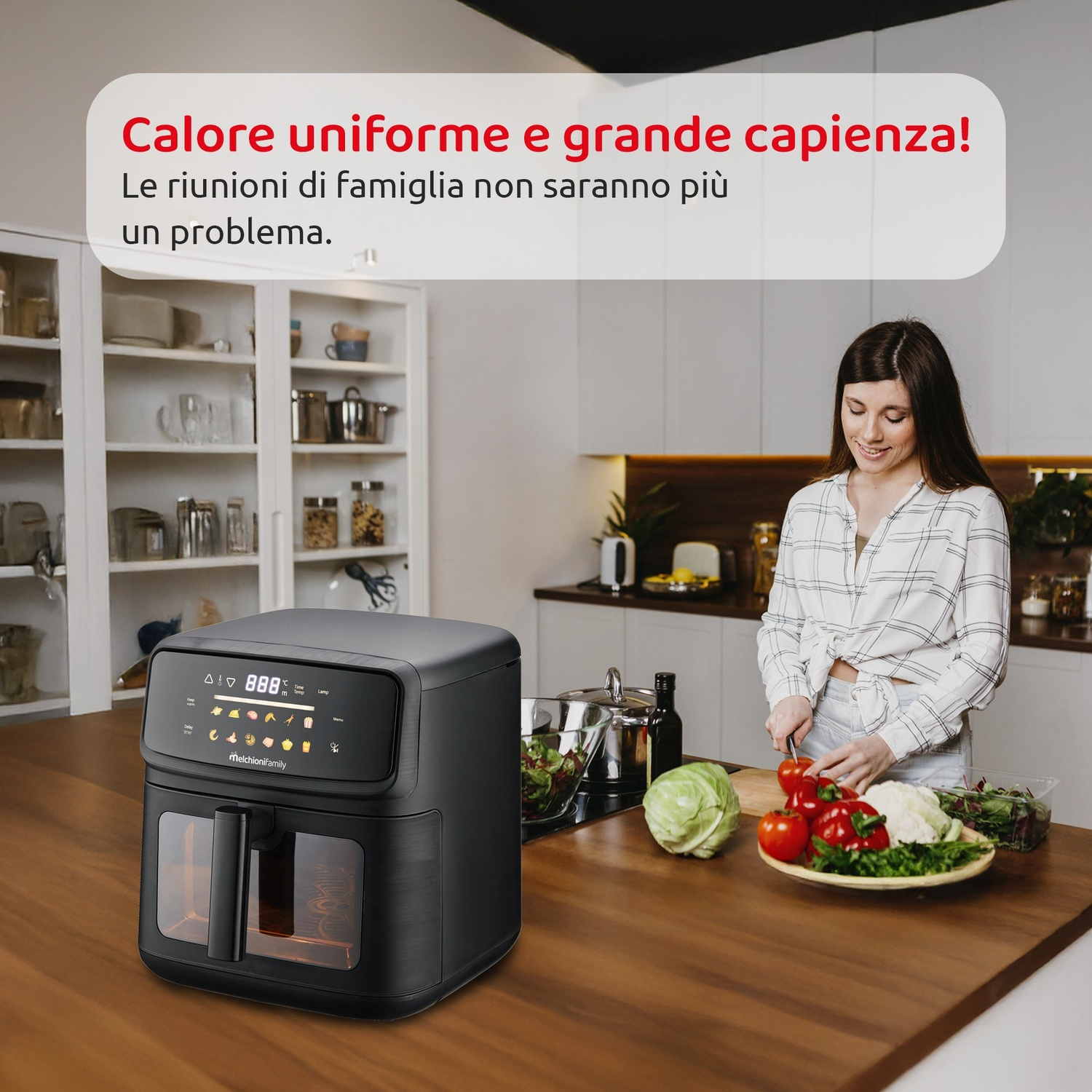 Una donna taglia pomodori in cucina con friggitrice ad aria nera.