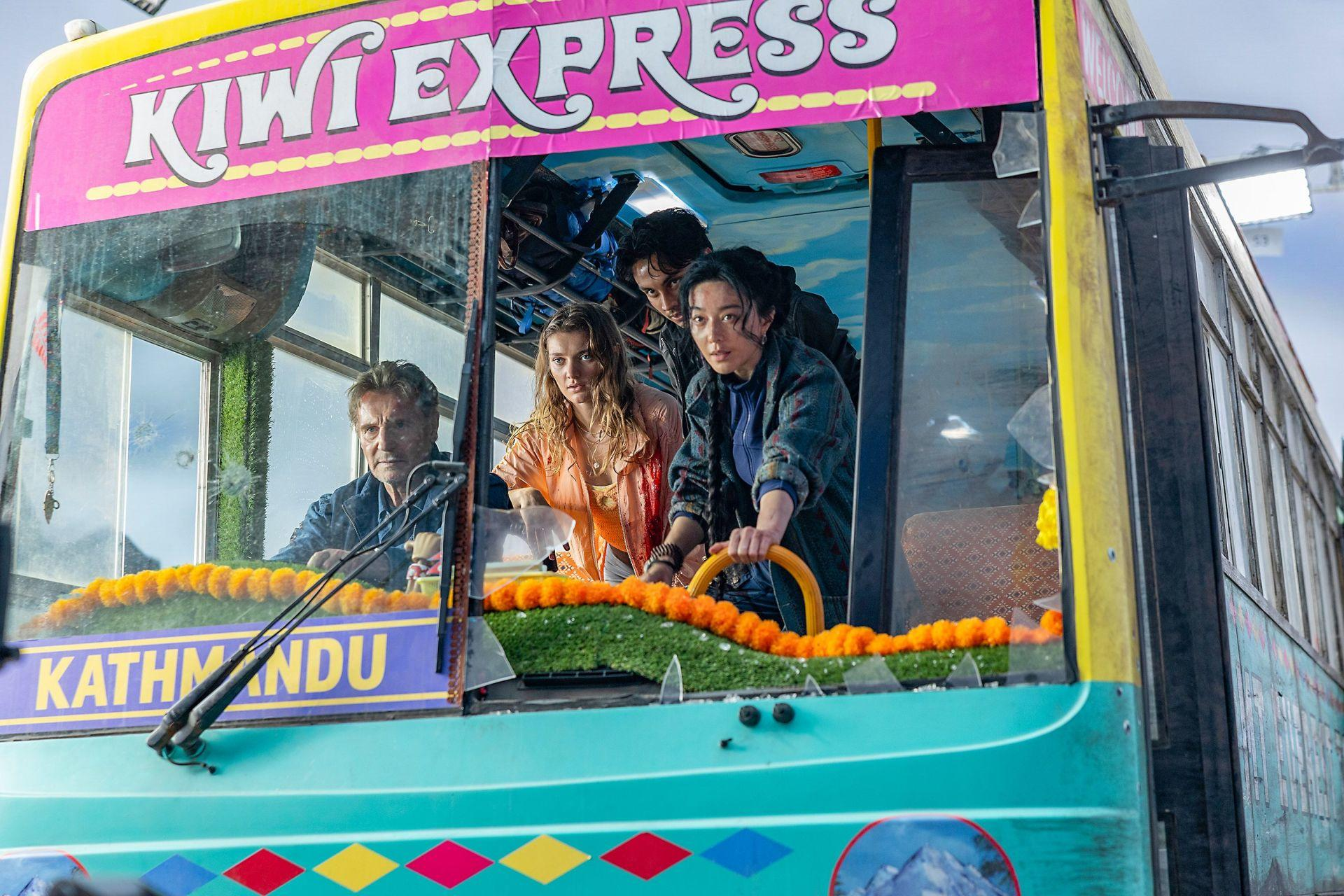 Menschen in einem bunten Bus mit der Aufschrift "Kiwi Express" und "Kathmandu".