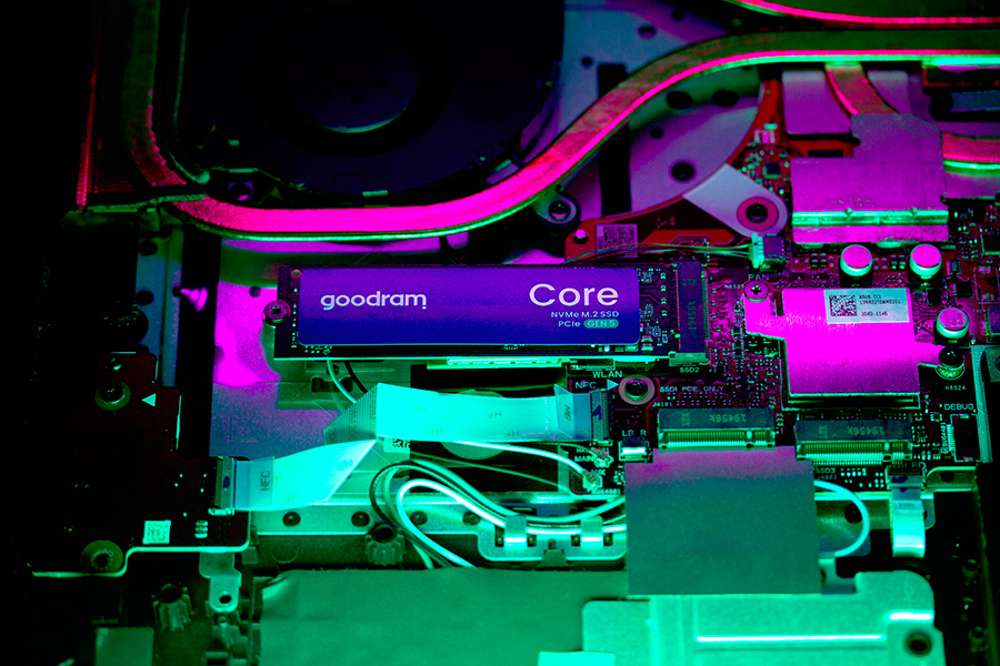 Dysk SSD NVMe M.2 Goodram Core na płycie obwodu, oświetlony różowymi i zielonymi światłami.
