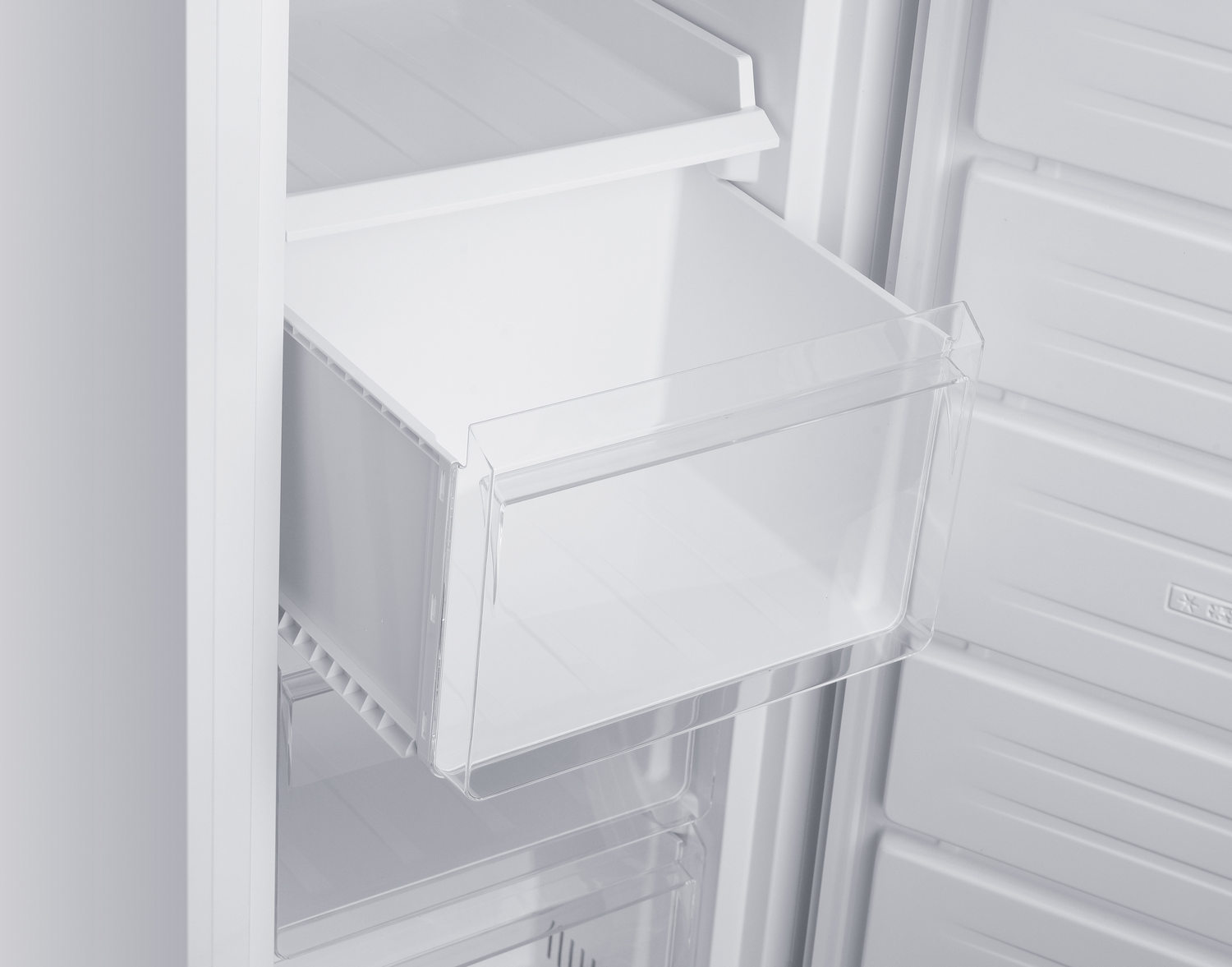 Interior de refrigerador blanco con un cajón transparente parcialmente extraído.