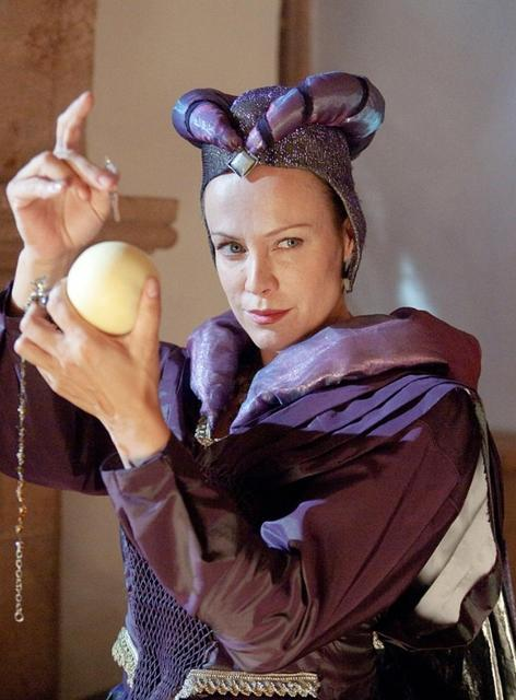 Eine Frau in einem lila Kostüm mit einem Ball in der Hand.