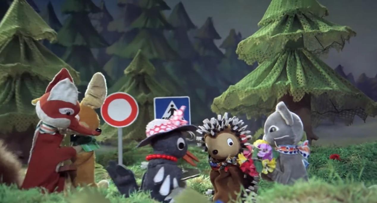 Puppen tiere, darunter ein Fuchs, Hase, Krähe, Igel und Maus, stehen bei Wald Bäumen und Schildern.