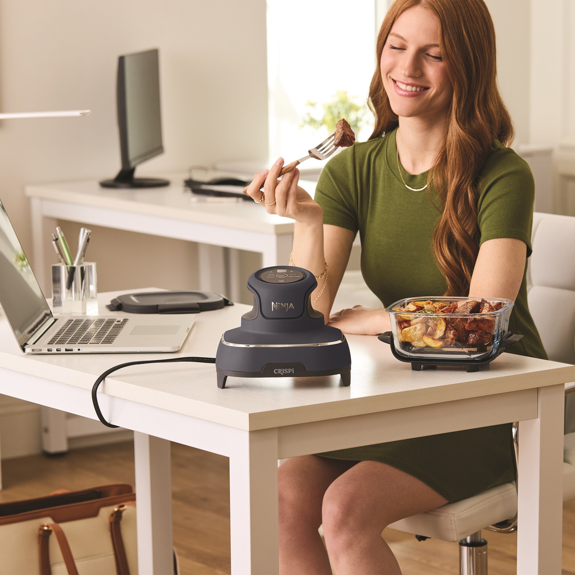 Kobieta je wołowinę i ziemniaki ze szklanej miski obok Ninja Crispi.