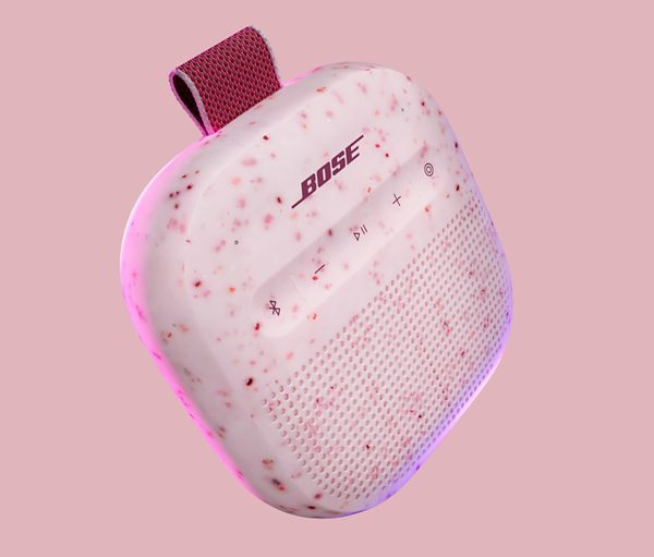 Różowy głośnik Bose w kropki z pętelką. Jasnoróżowe tło.
