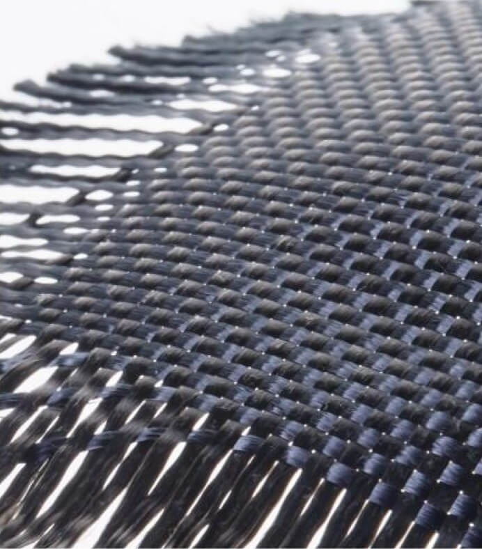 Zbliżenie ciemnej, tkanej tekstury z postrzępionymi krawędziami po lewej stronie.