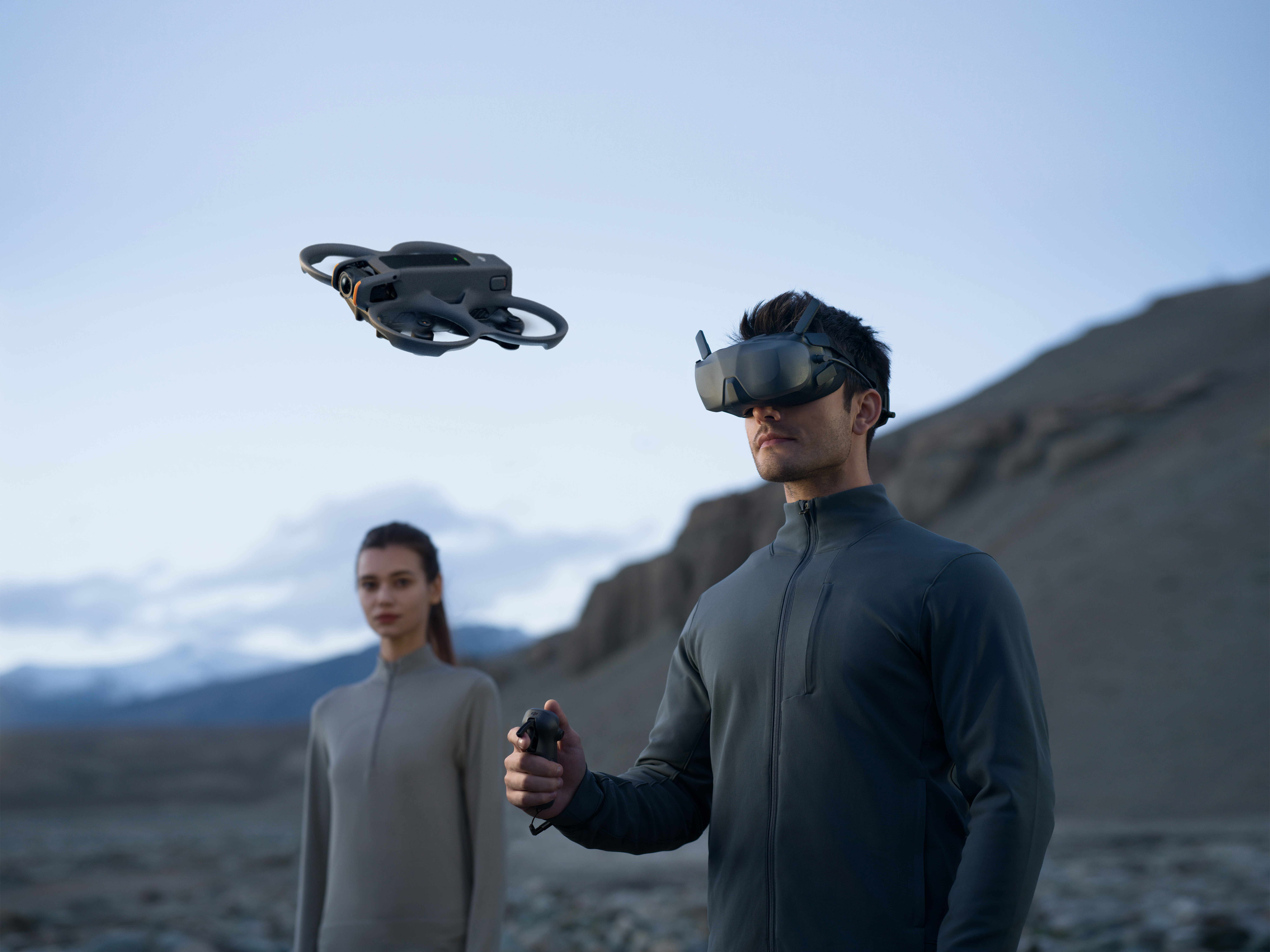 VR gözlüklü adam drone kullanıyor. Kadın arkada duruyor.