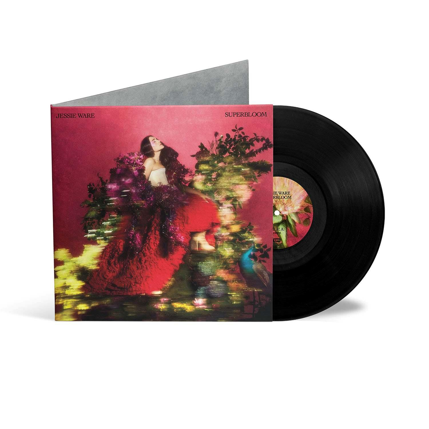 Jessie Ware mit Schallplatte und Hülle mit Blumenmotiv und Pfau.
