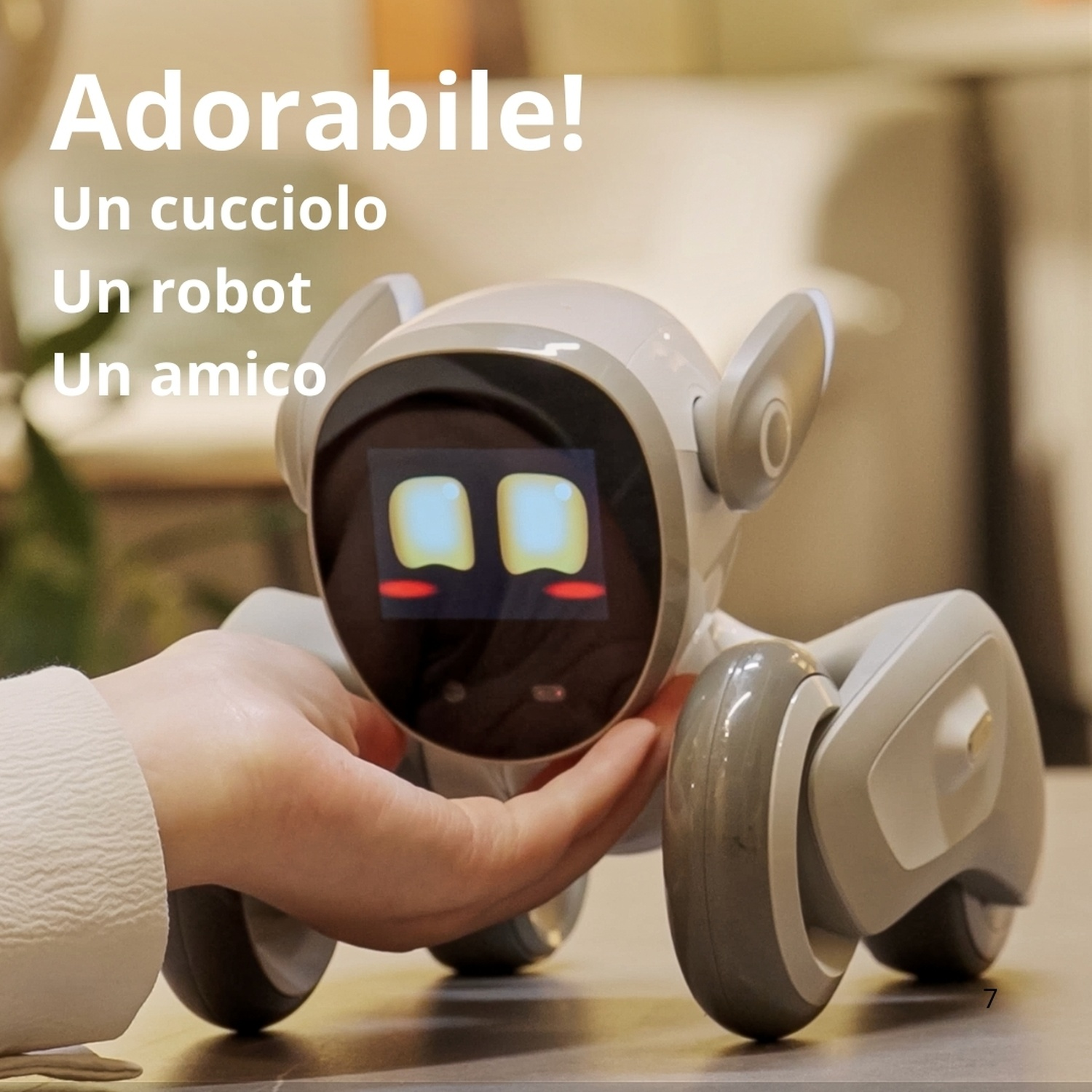 Un robot bianco con ruote e schermo è tenuto da una mano.