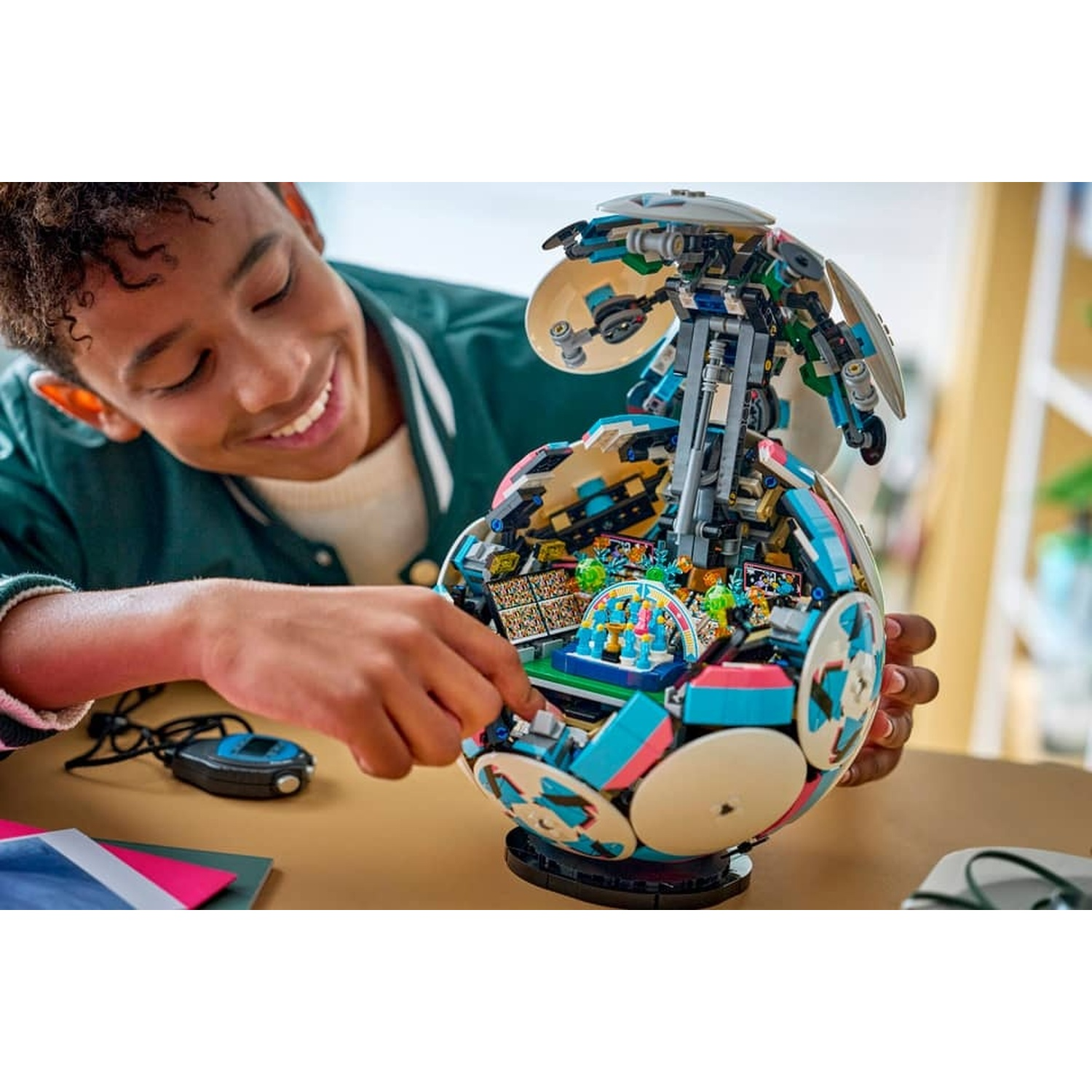 Un ragazzo costruisce un pallone da calcio Lego colorato con interno.