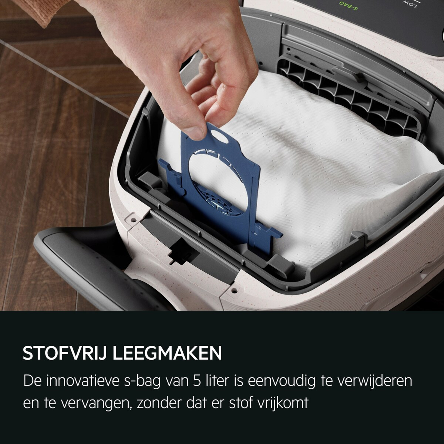 A hand removes a blue dust bag holder from a vacuum cleaner.