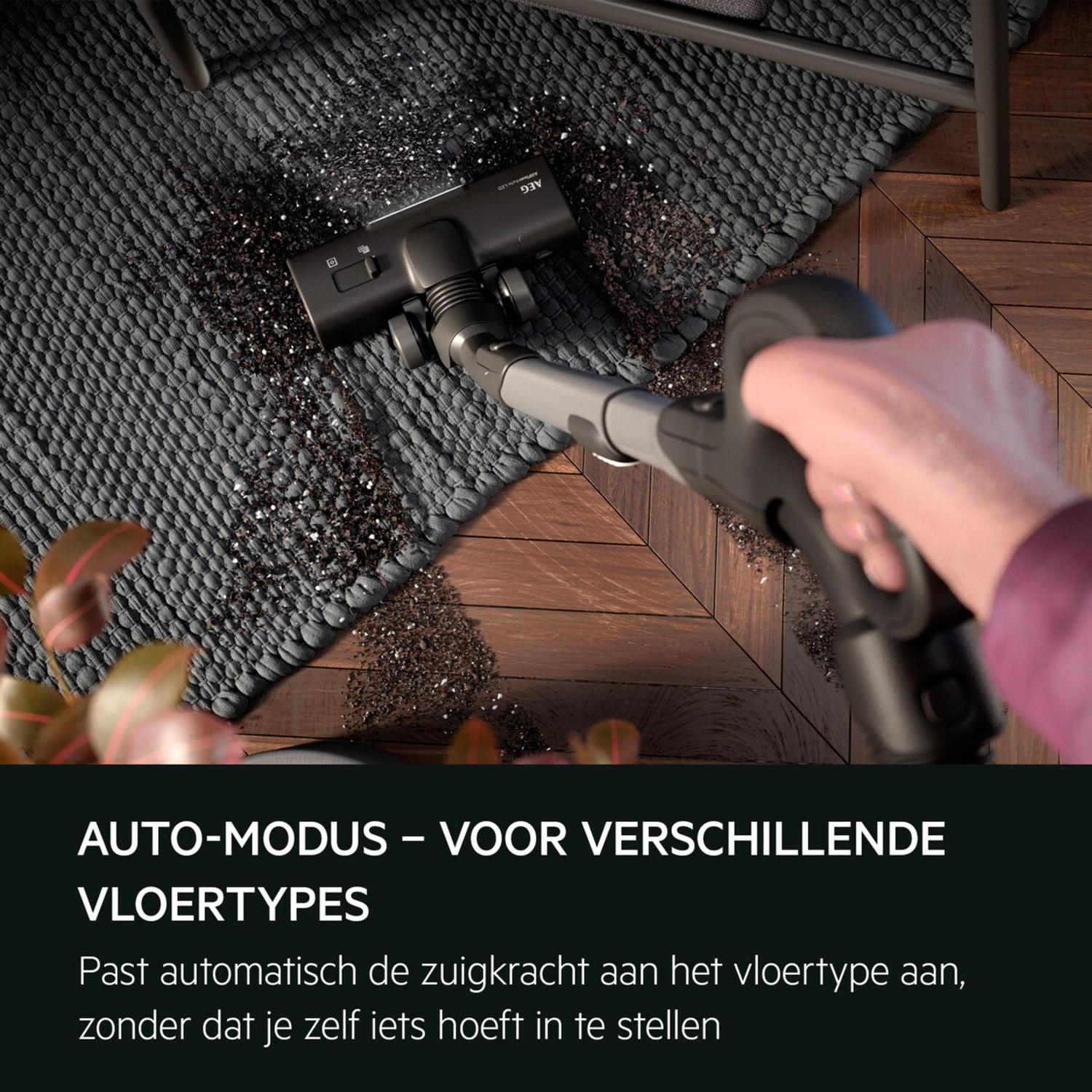 Vacuum cleaner head cleans dirt from a grey rug on a wooden floor.