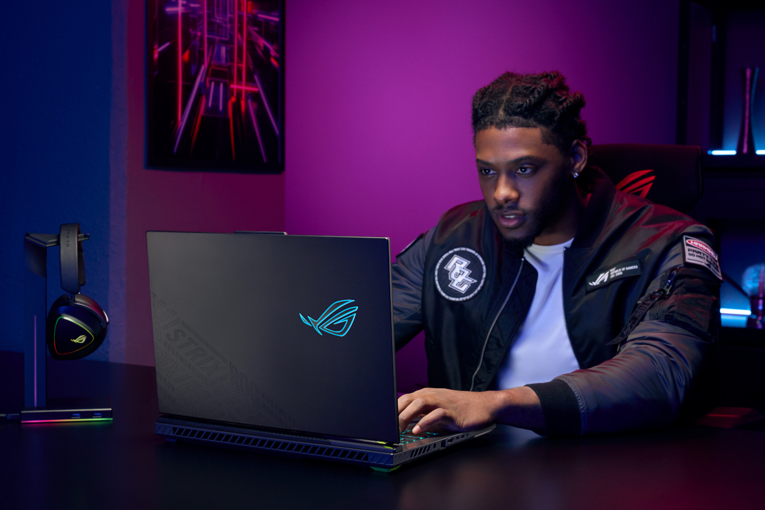 Man zit aan een gaming laptop, koptelefoon in de buurt. Neonverlichting.