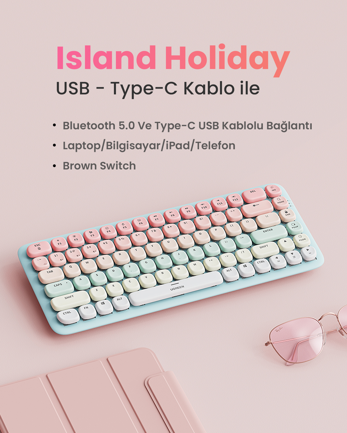 Pastel renkli, Bluetooth 5.0 ve USB-C bağlantılı klavye, güneş gözlüğünün yanında.