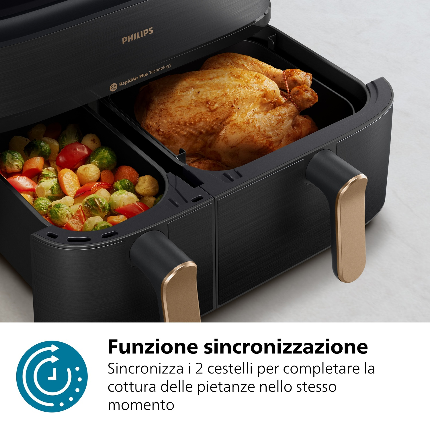 Una friggitrice ad aria Philips nera con due cassetti, uno con pollo arrosto, l'altro con verdure.