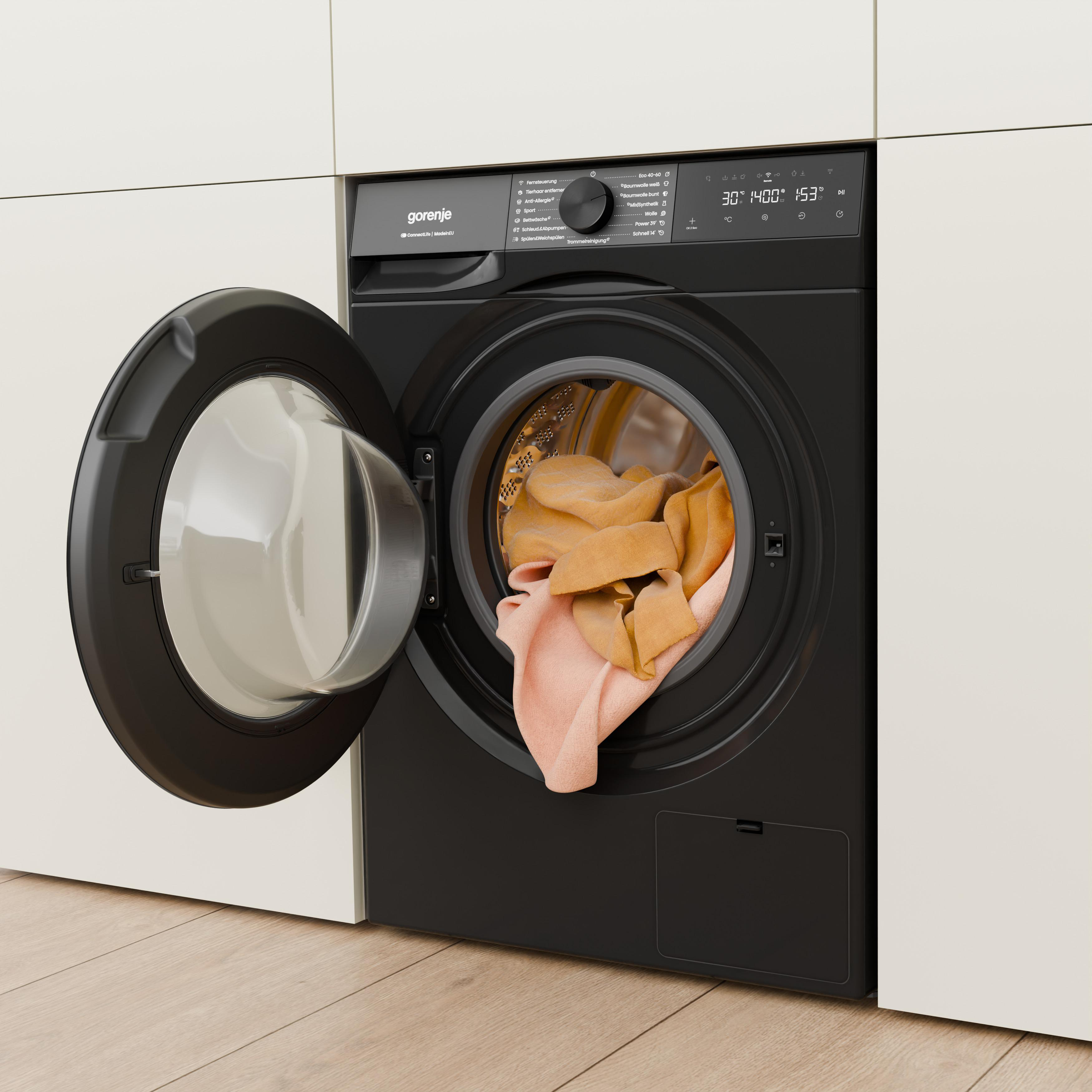 Eine schwarze Gorenje Waschmaschine mit offener Tür, gefüllt mit Kleidung.