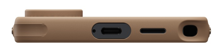 Zbliżenie brązowego urządzenia z portem ładowania, gniazdem SIM i grillem głośnika.